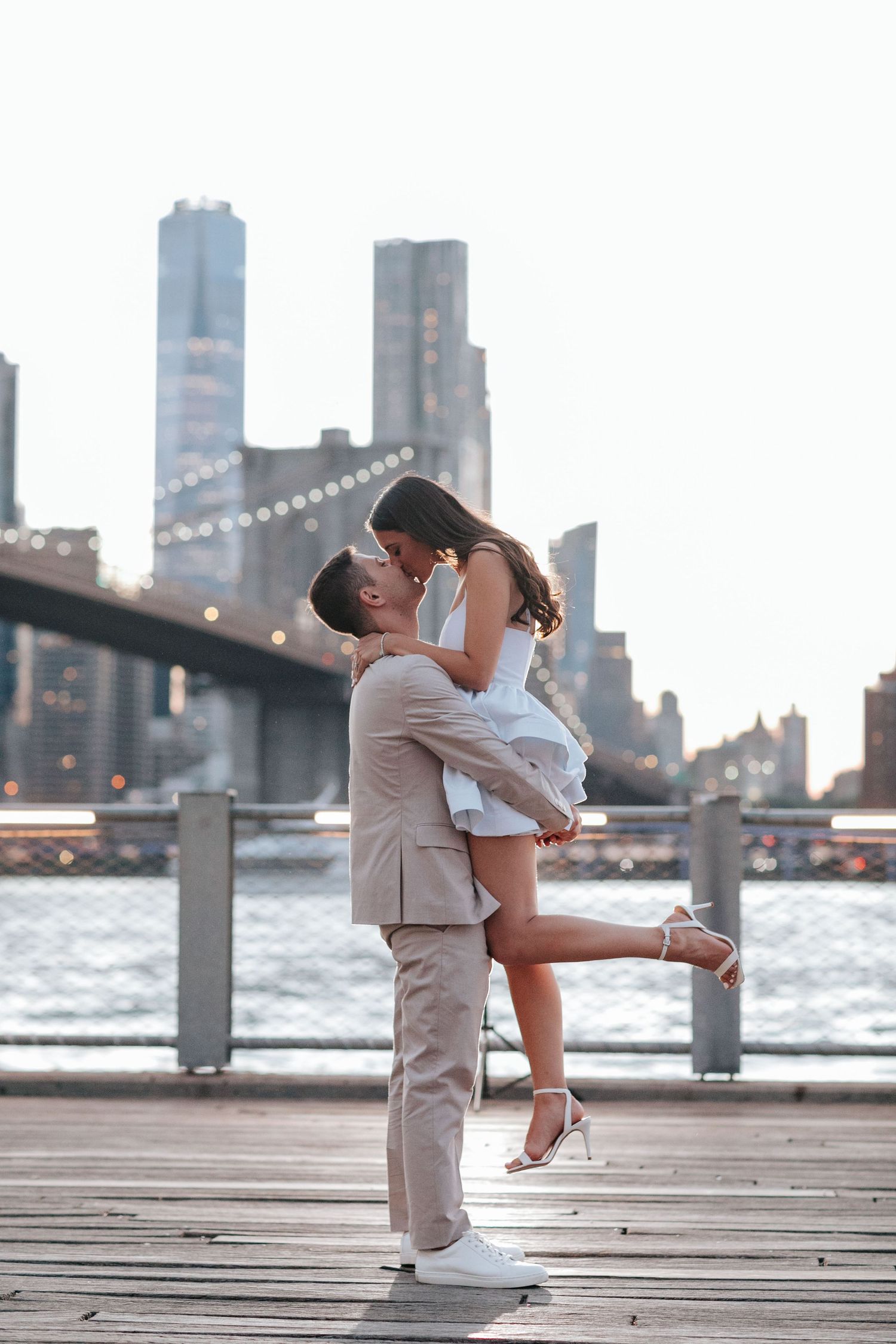 A romantic dance on a waterfront pier with the city skyline at dusk.