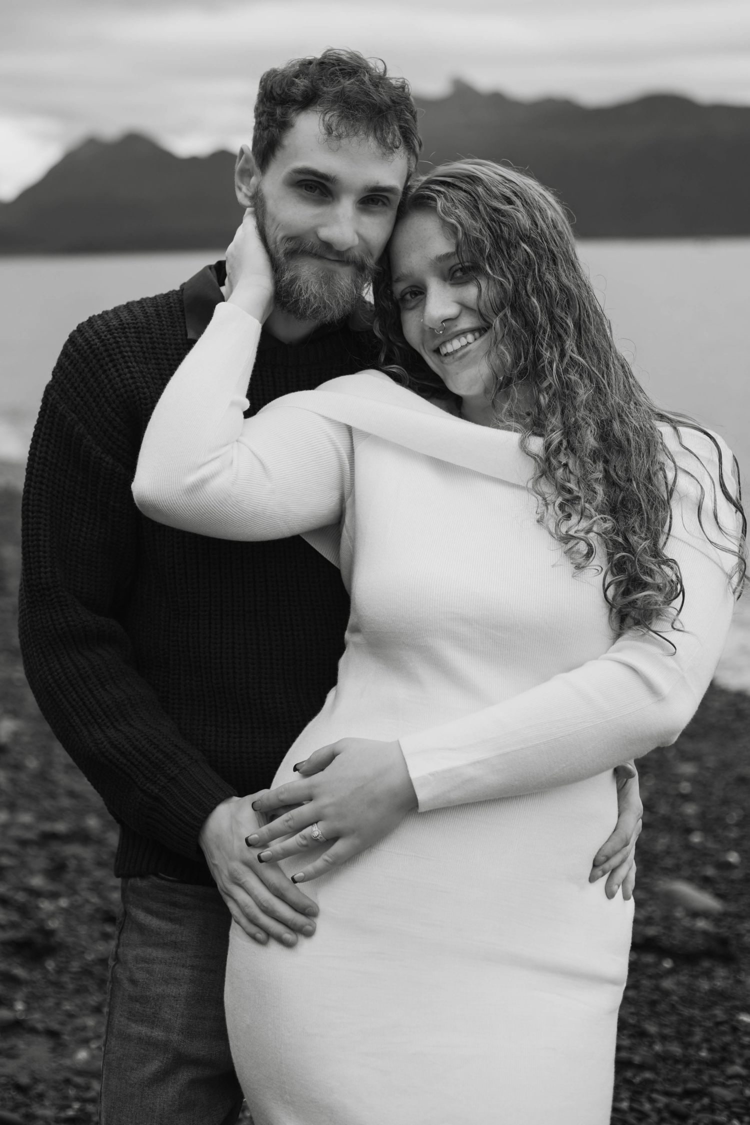 Black and white photos of a couple dancing and laughing together by a lake.