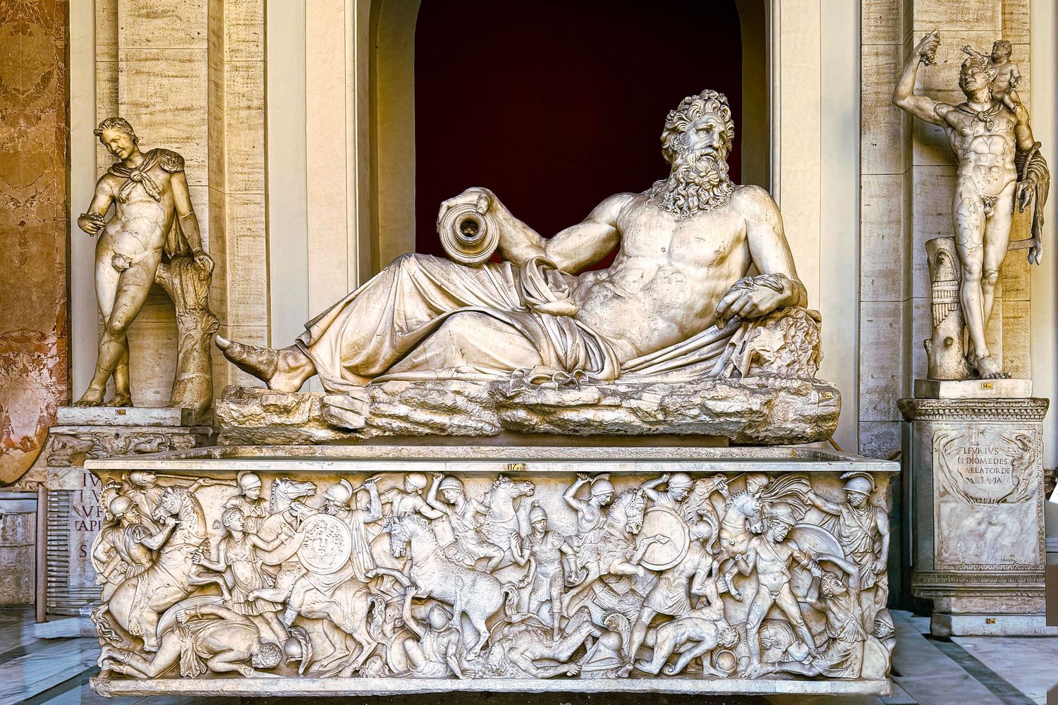 Classical marble sculptures and statues adorn the exterior wall of an ornate European building or palace.