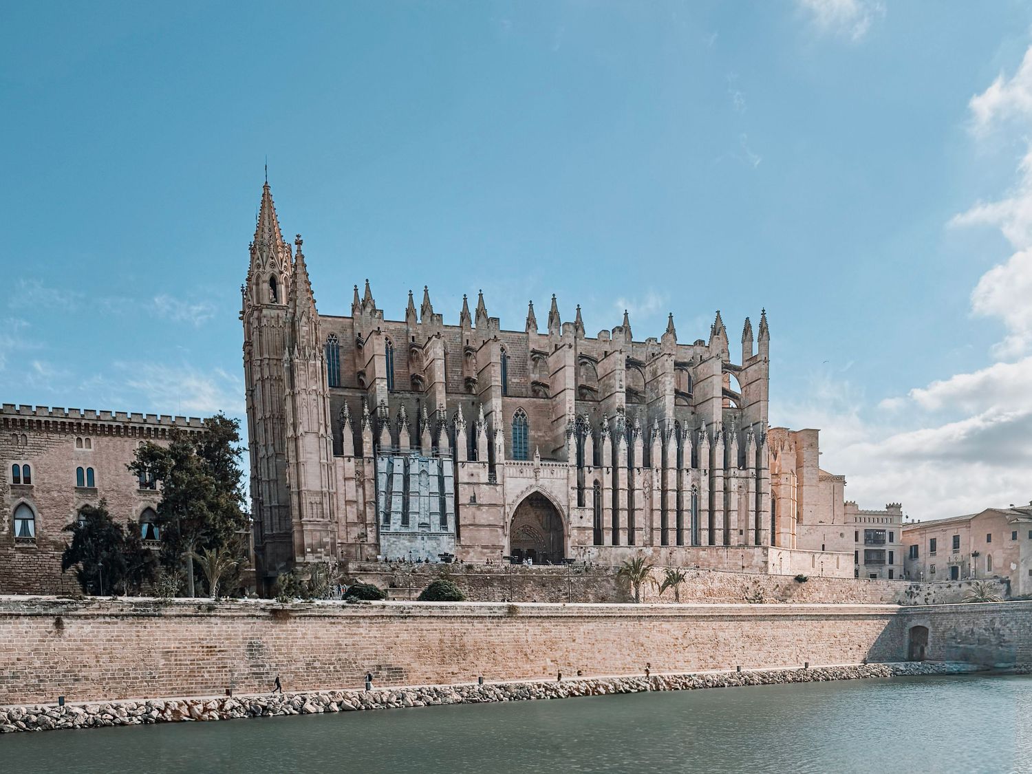 Panoramic view of the historic Palma de Mallorca Cathedral with its Gothic architecture reflecting in the Mediterranean Sea.