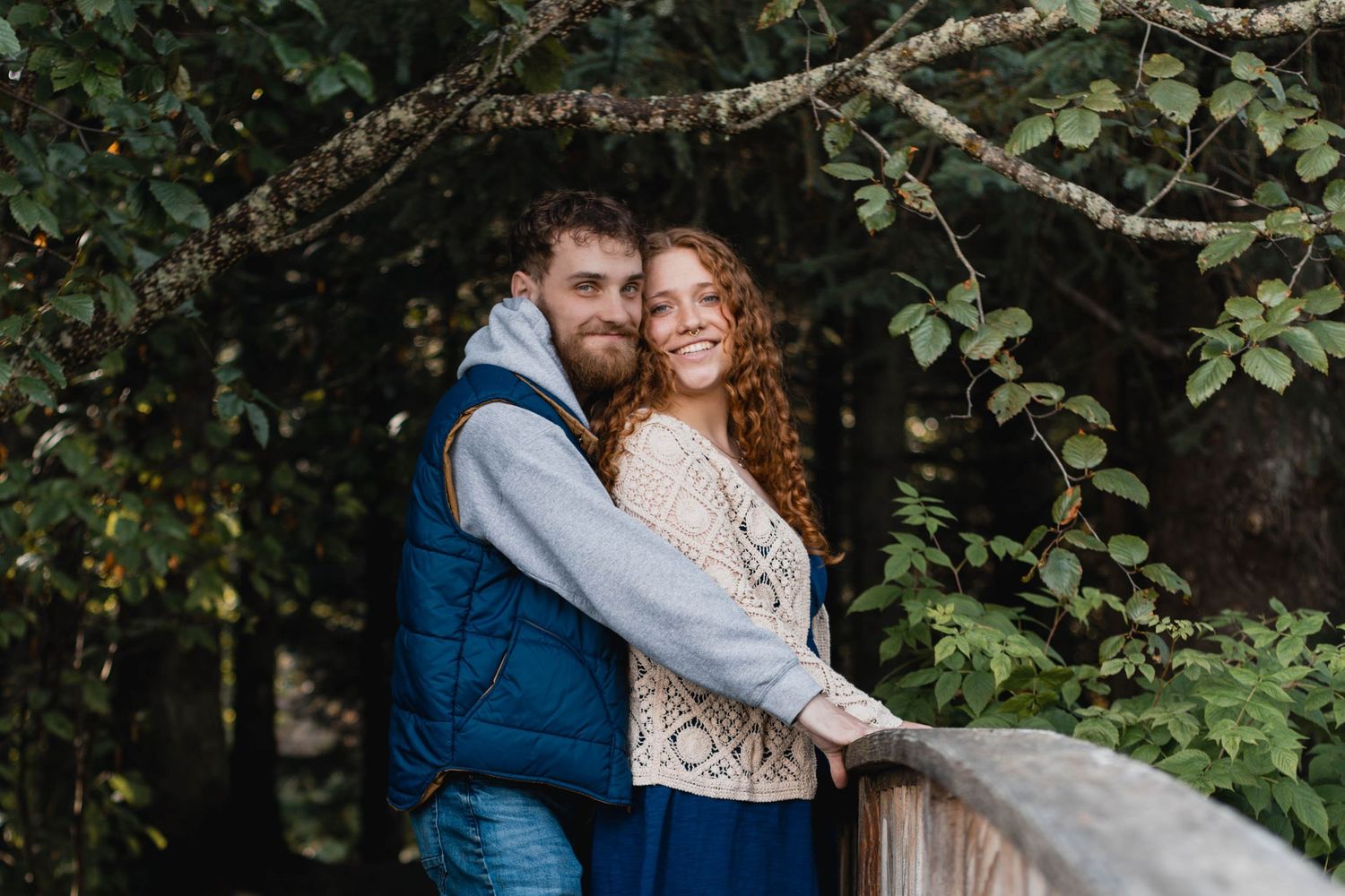 A romantic couple embraces in lush garden setting during golden hour outdoor photo session.