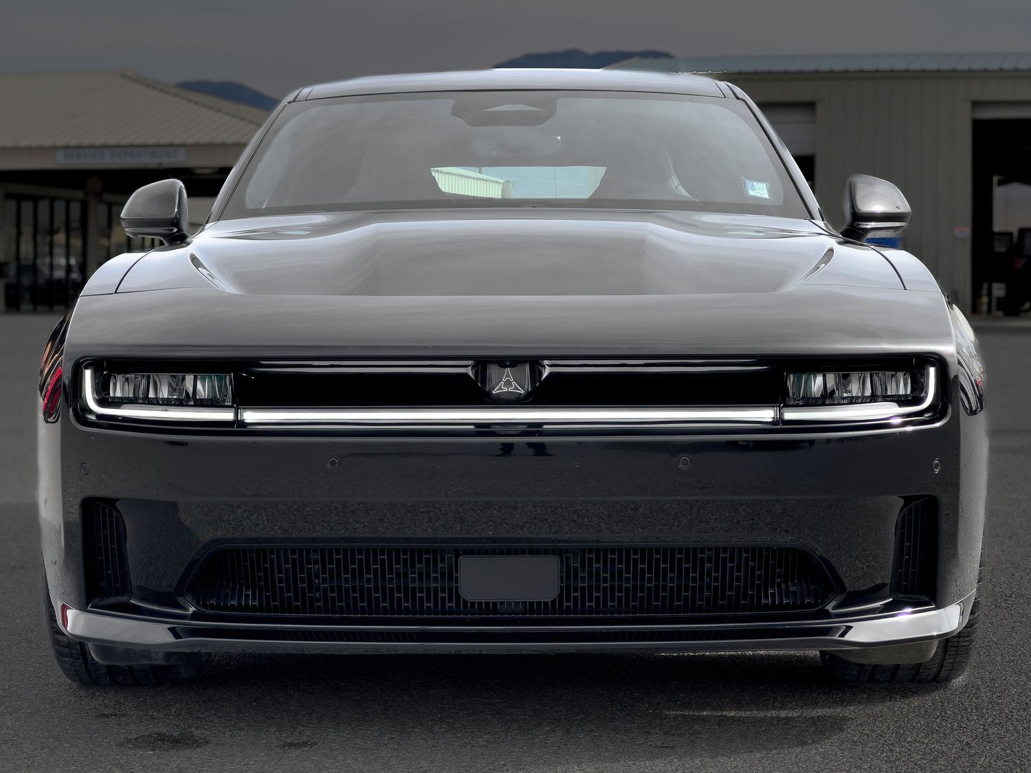 Close-up automotive photography of a sleek black all-electric Dodge Charger showcasing modern design at a Pahrump Nevada dealership by Oasis