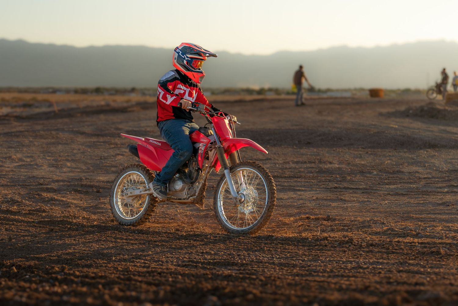 Action photography of a dirt bike rider speeding through a dusty trail captured by Oasis Digital.