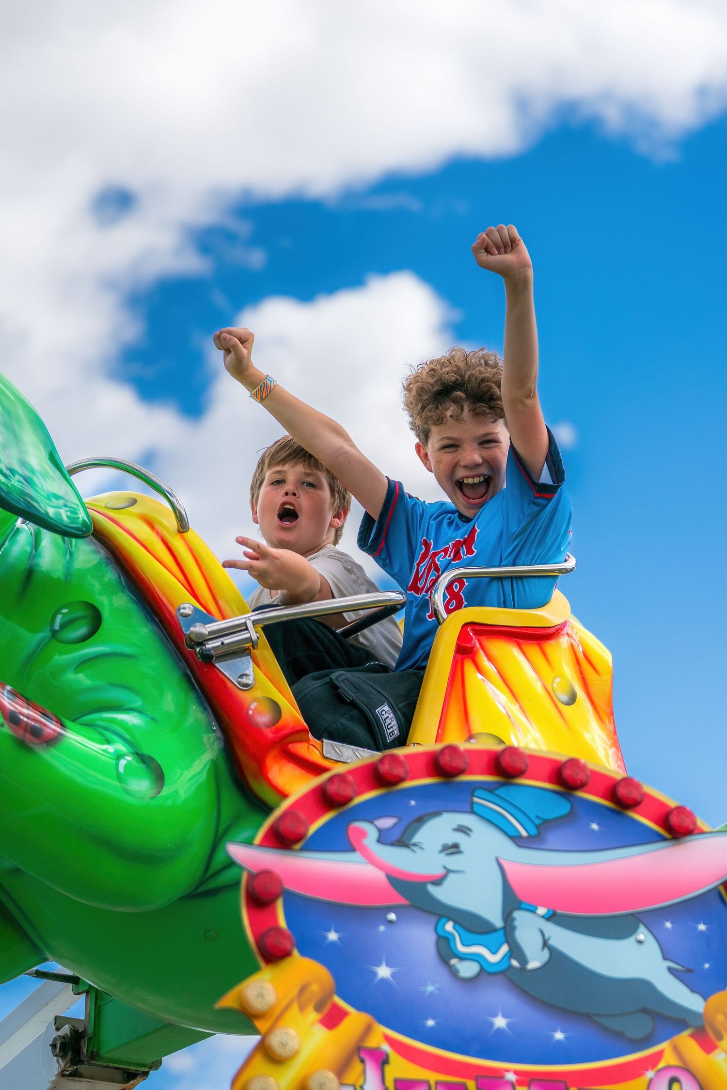 Candid photography of people enjoying rides and games at a local carnival by Oasis Digital.
