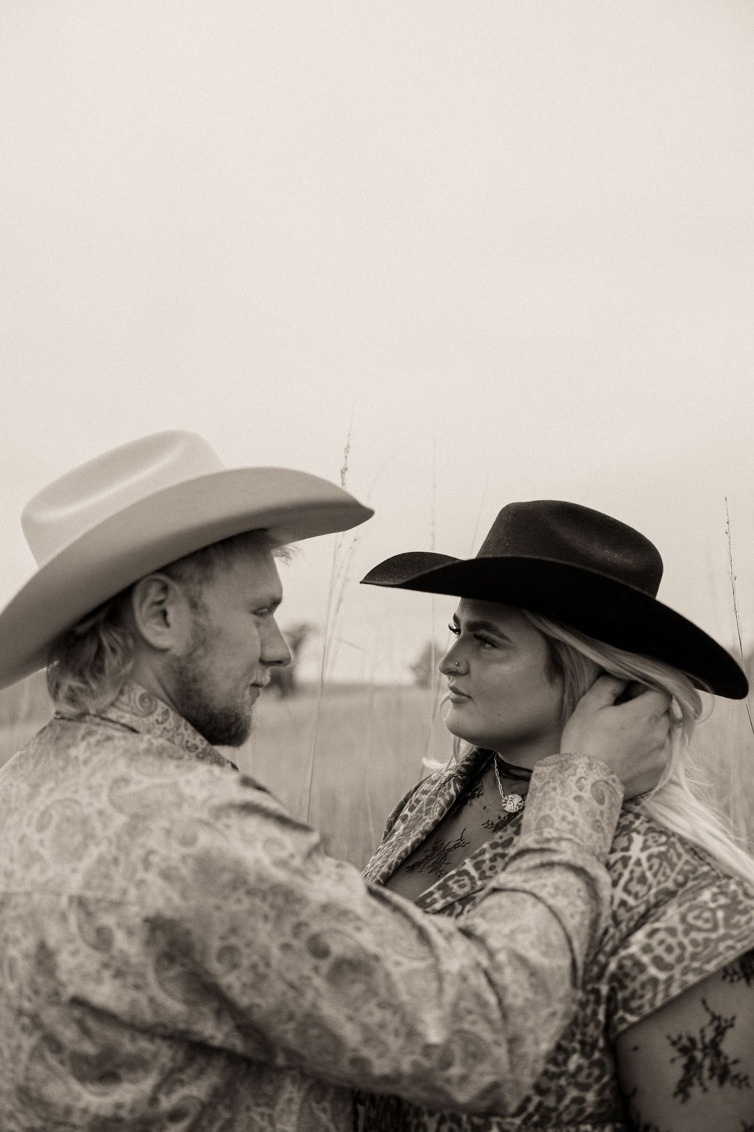 A series of black and white photographs showing two people in cowboy hats sharing intimate moments in sequence.