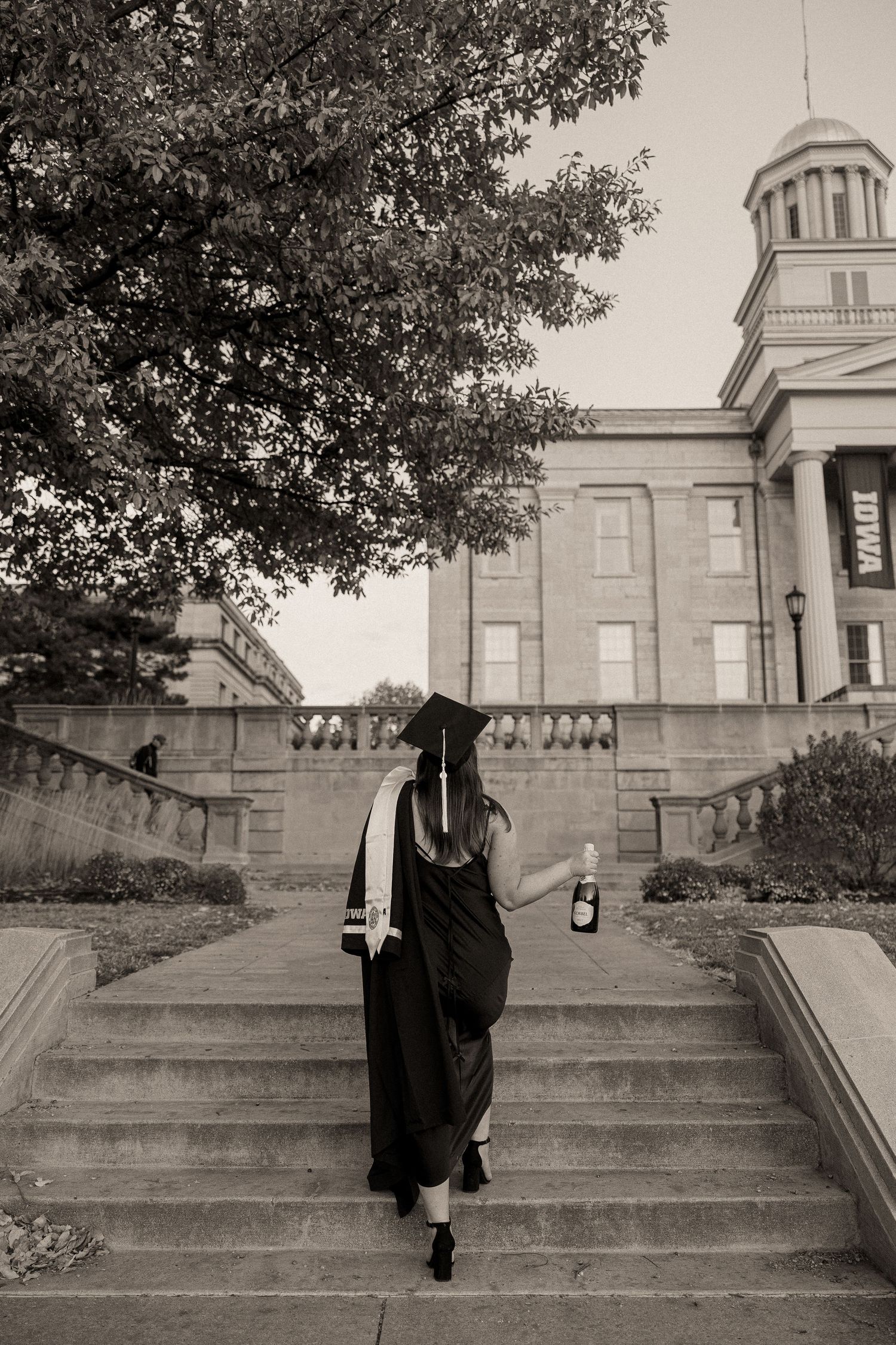 A sequence of black and white photos showing a person in dark clothing ascending stone steps in front of a building.