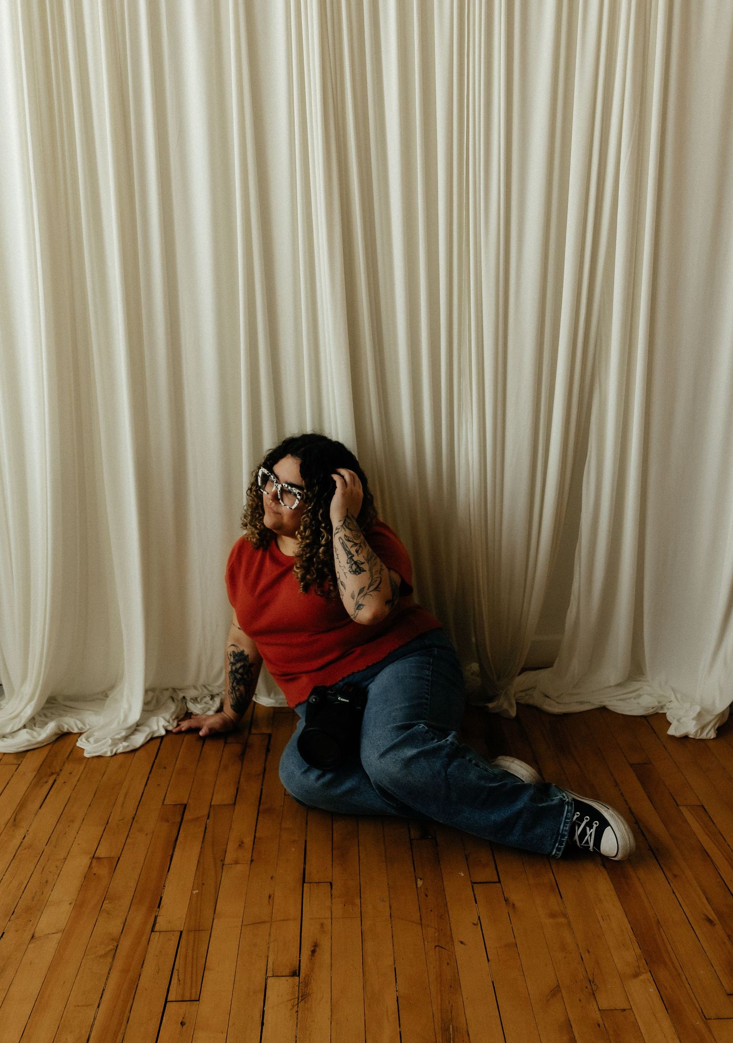 Three sequential photos show someone curled up on a wooden floor against white curtains in a fetal position.