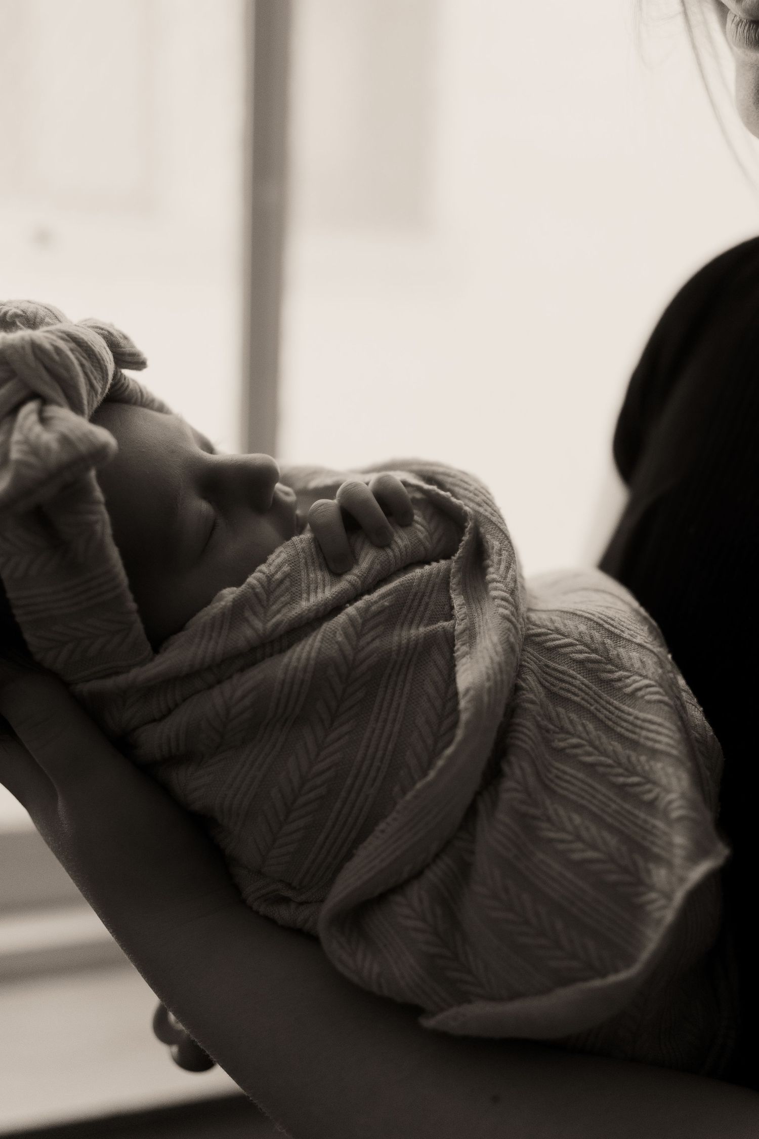 Artistic black and white photograph of gentle embrace with textured fabric.