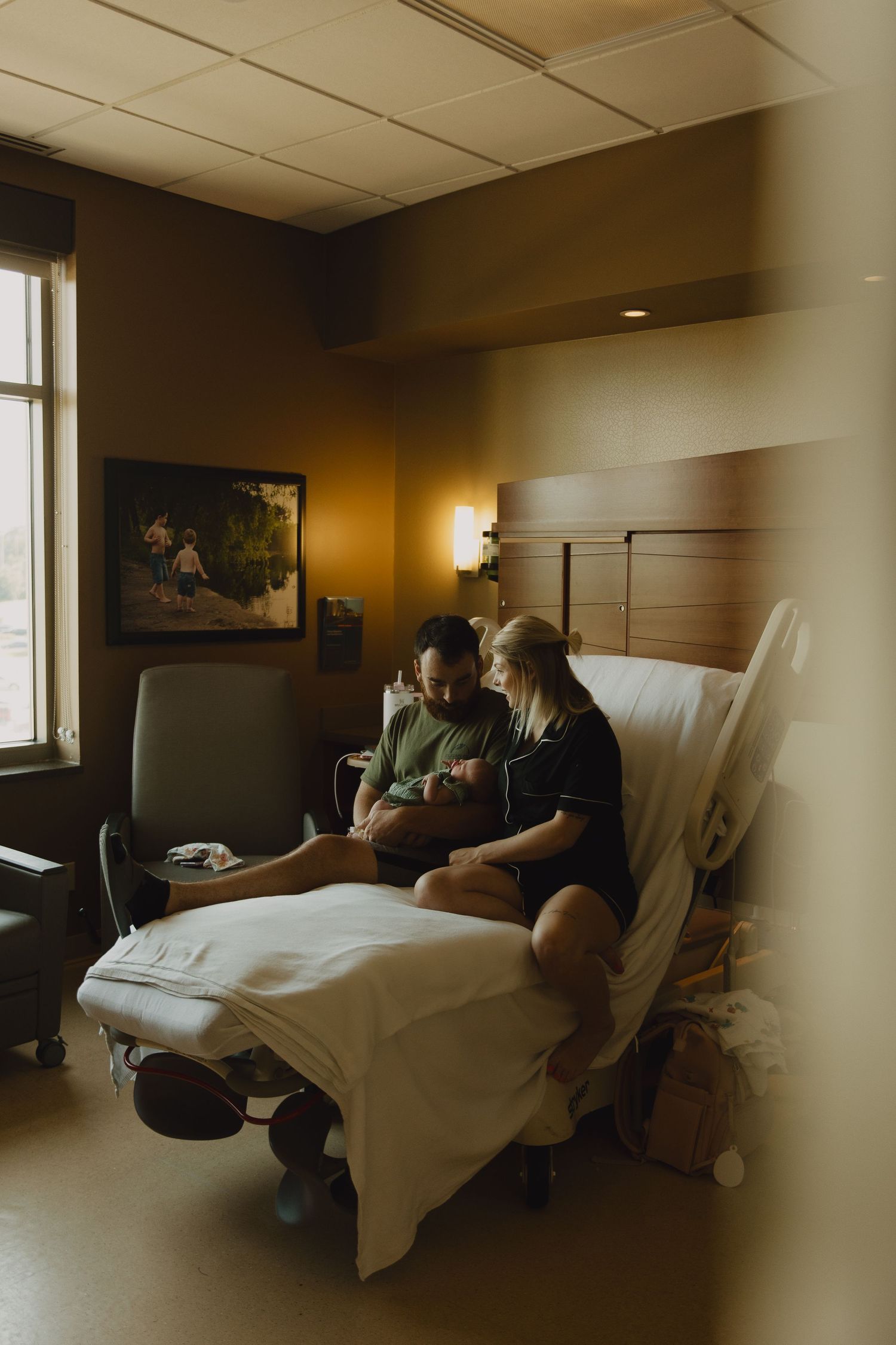 Hospital room scene with medical equipment and bed visible in warm ambient lighting.