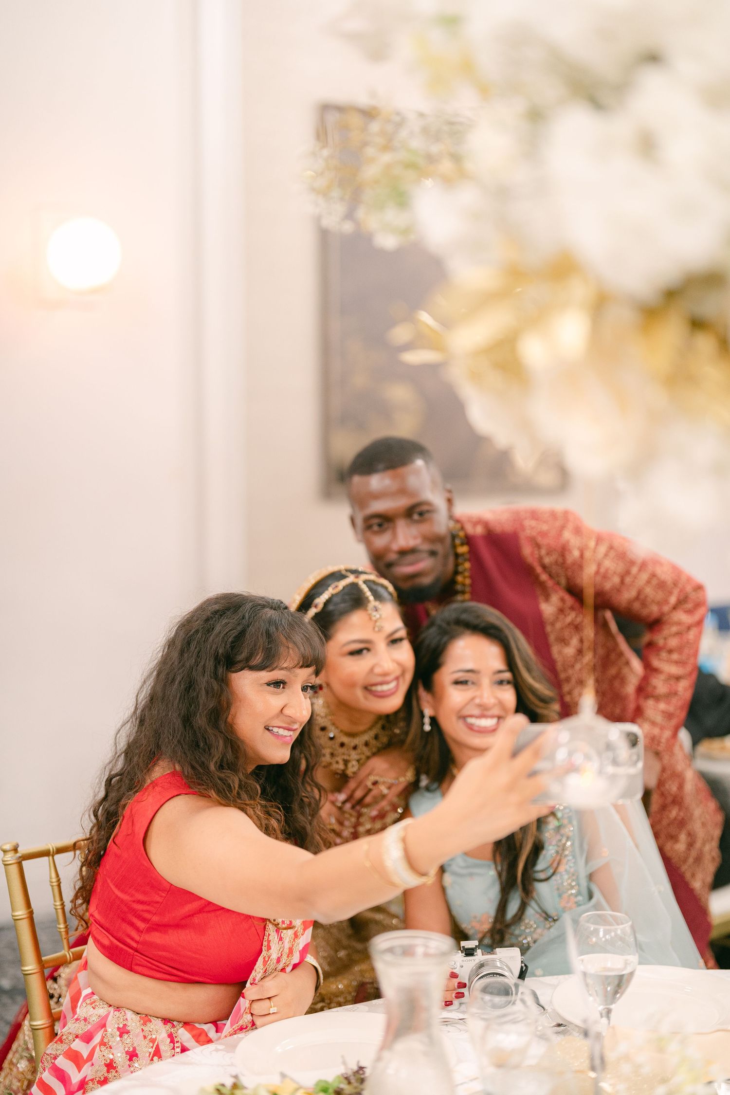 Wedding reception guests taking selfies and enjoying celebrations at an elegant table setting.