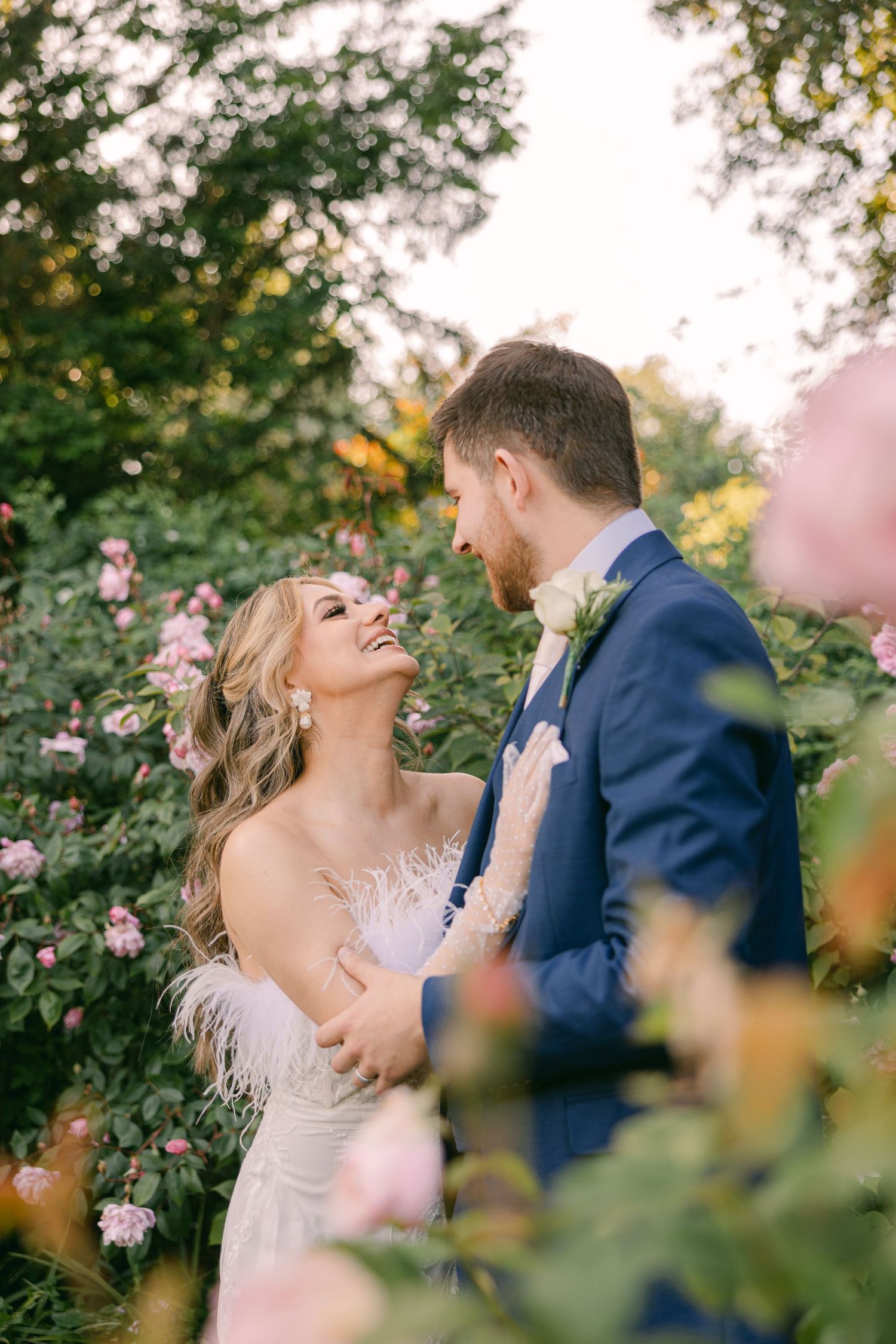 Romantic wedding portraits captured among blooming pink roses in a garden setting in Regent's Park.