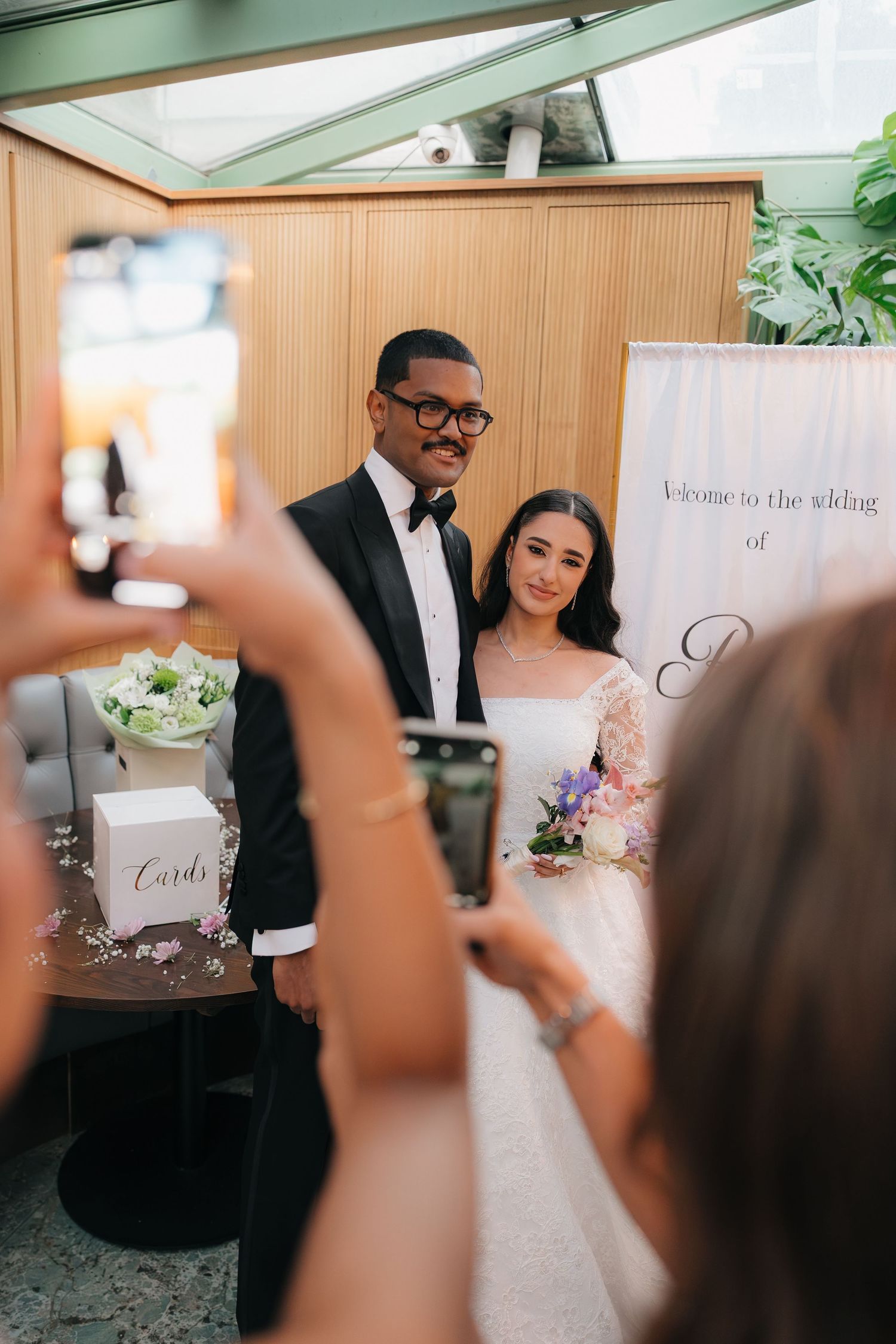 Wedding reception scene with decorative signage and wooden paneled walls.