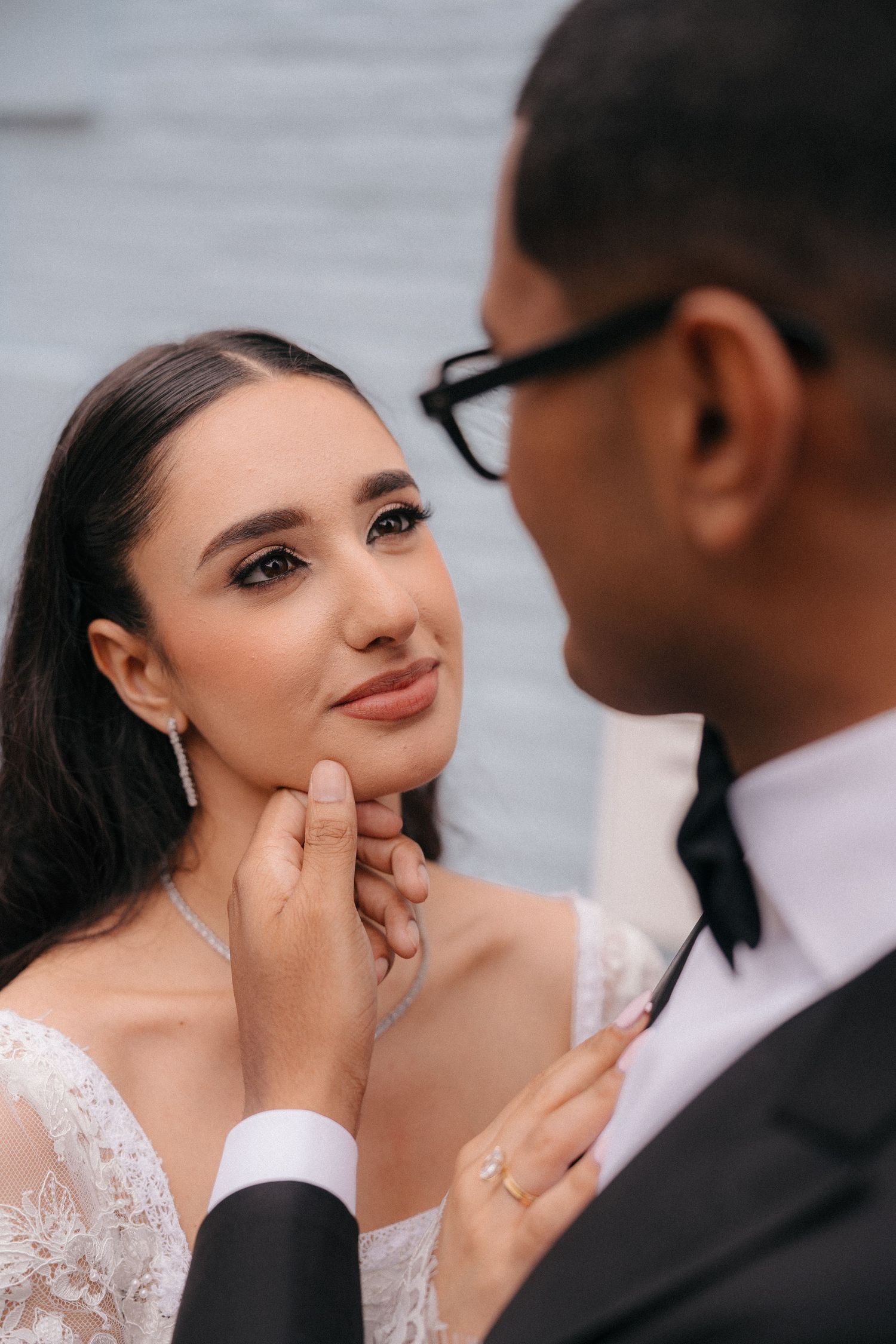 Intimate close-up wedding portrait against white wall.