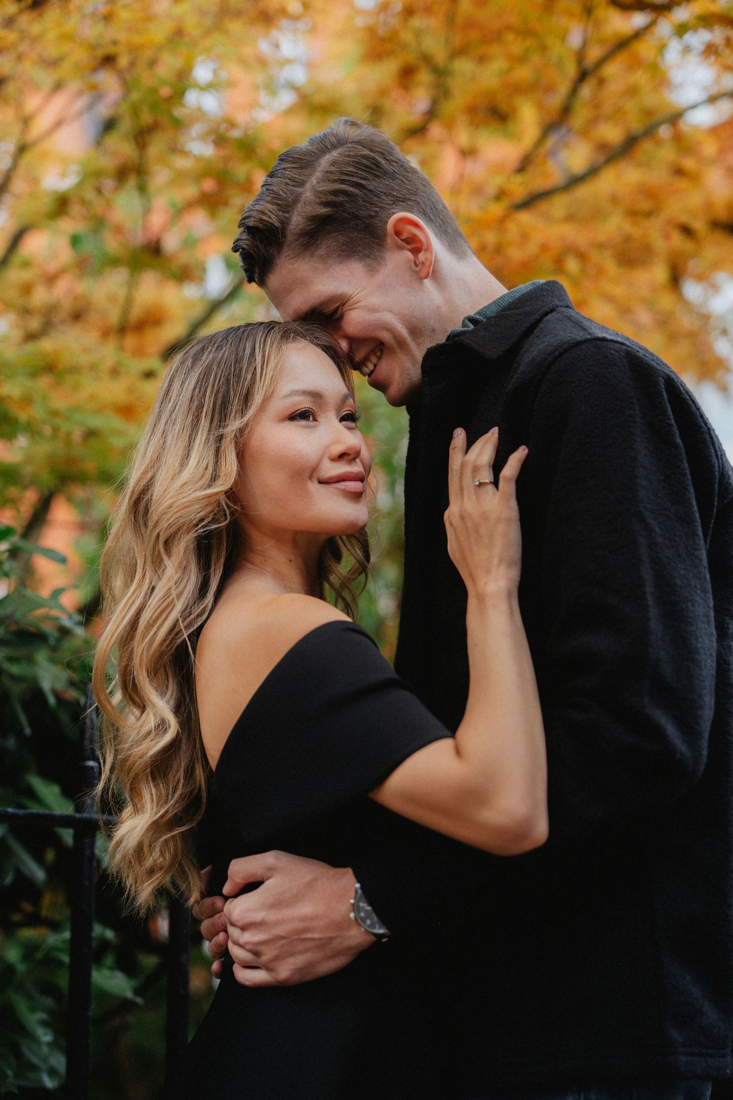 Romantic autumn engagement photos with fall foliage in the background.