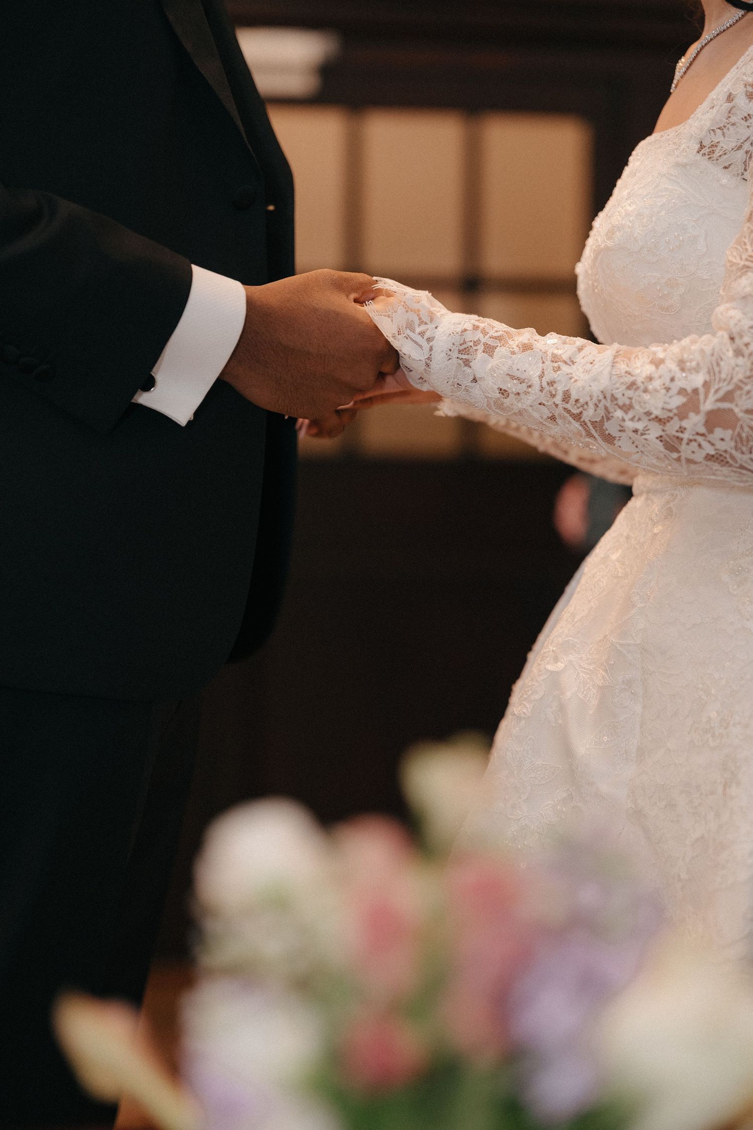 Close-up details of a bride and groom exchanging rings during their wedding ceremony.