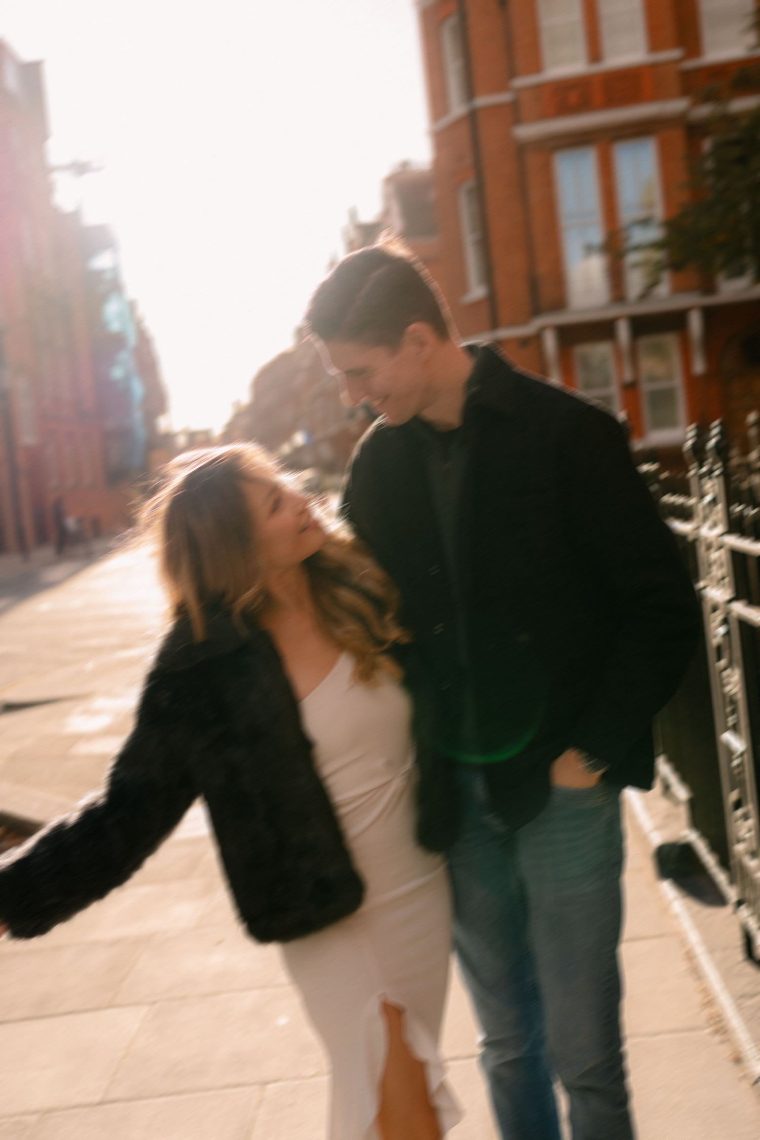 Couple sharing romantic moments in sunlit urban street.