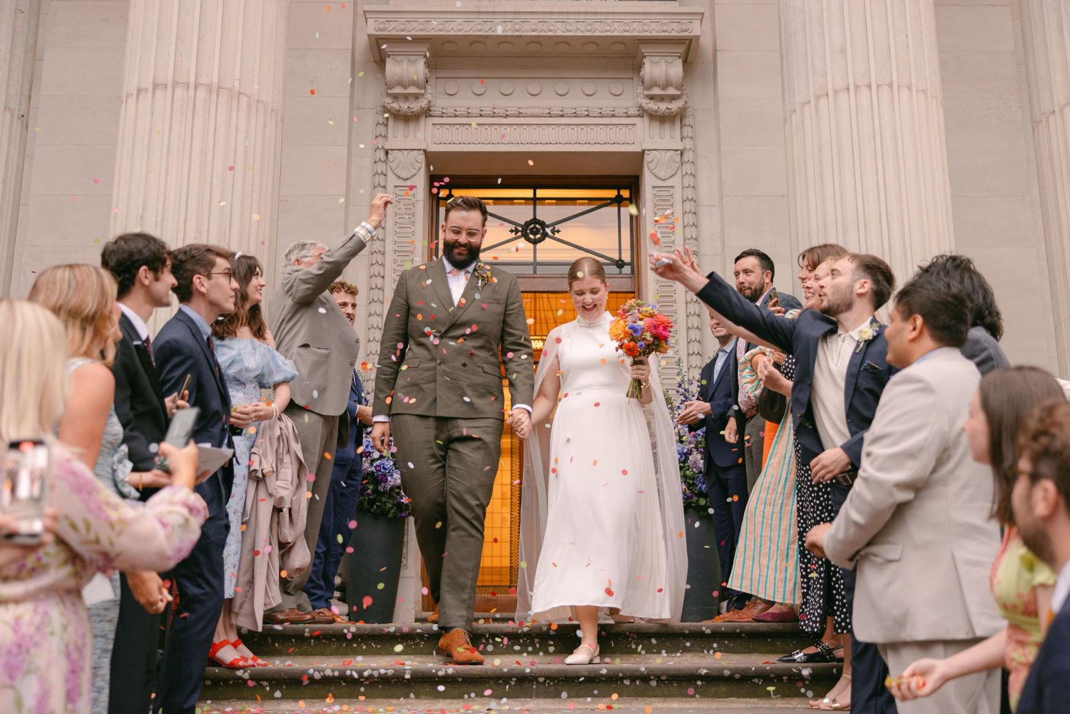 Wedding celebration inside an elegant venue with classical columns and festive atmosphere.