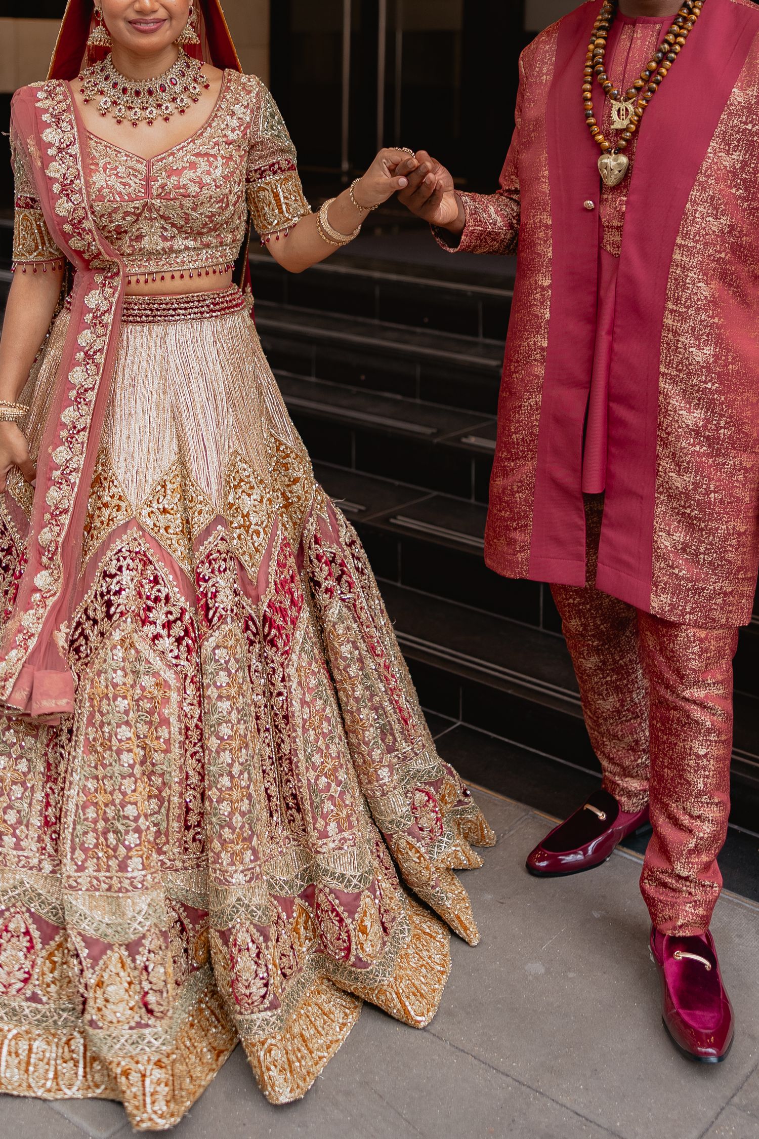 Close-up details of pink and gold embroidered wedding attire and matching footwear.