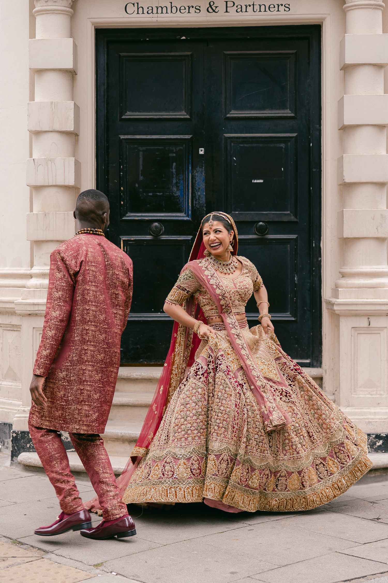 Traditional Indian wedding attire photographed outside Chambers & Partners building with classic architecture.