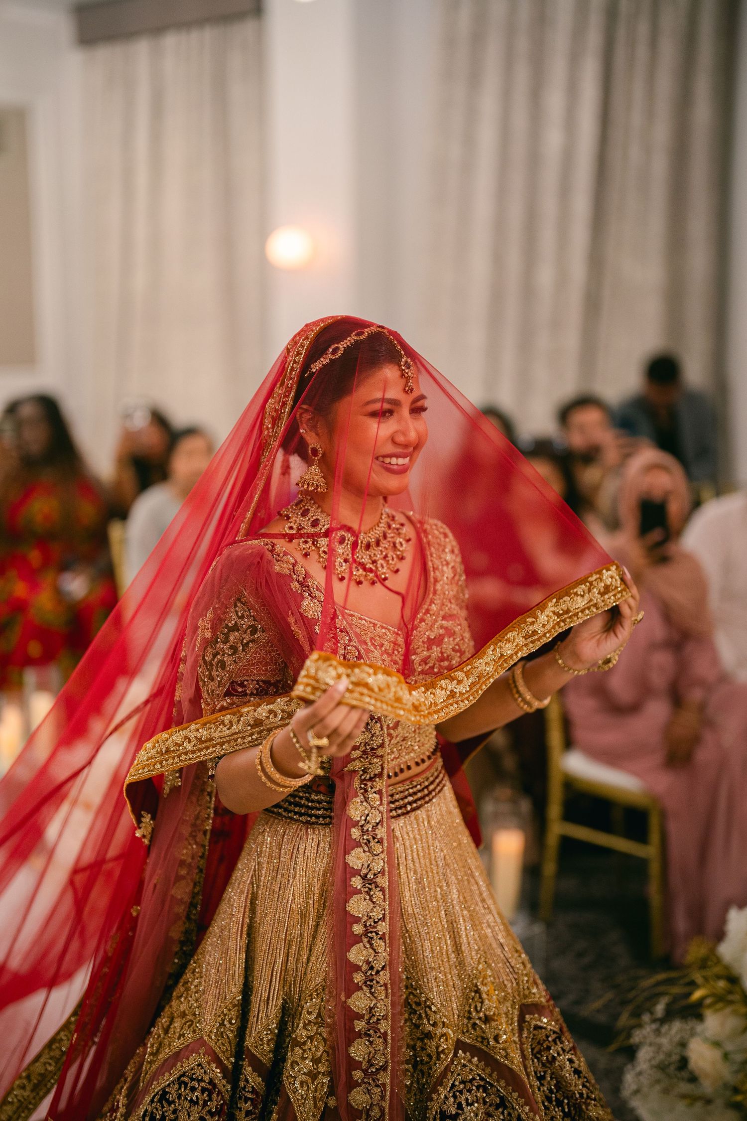 Elegant wedding celebration with gold and red decor featuring traditional Indian bridal attire.
