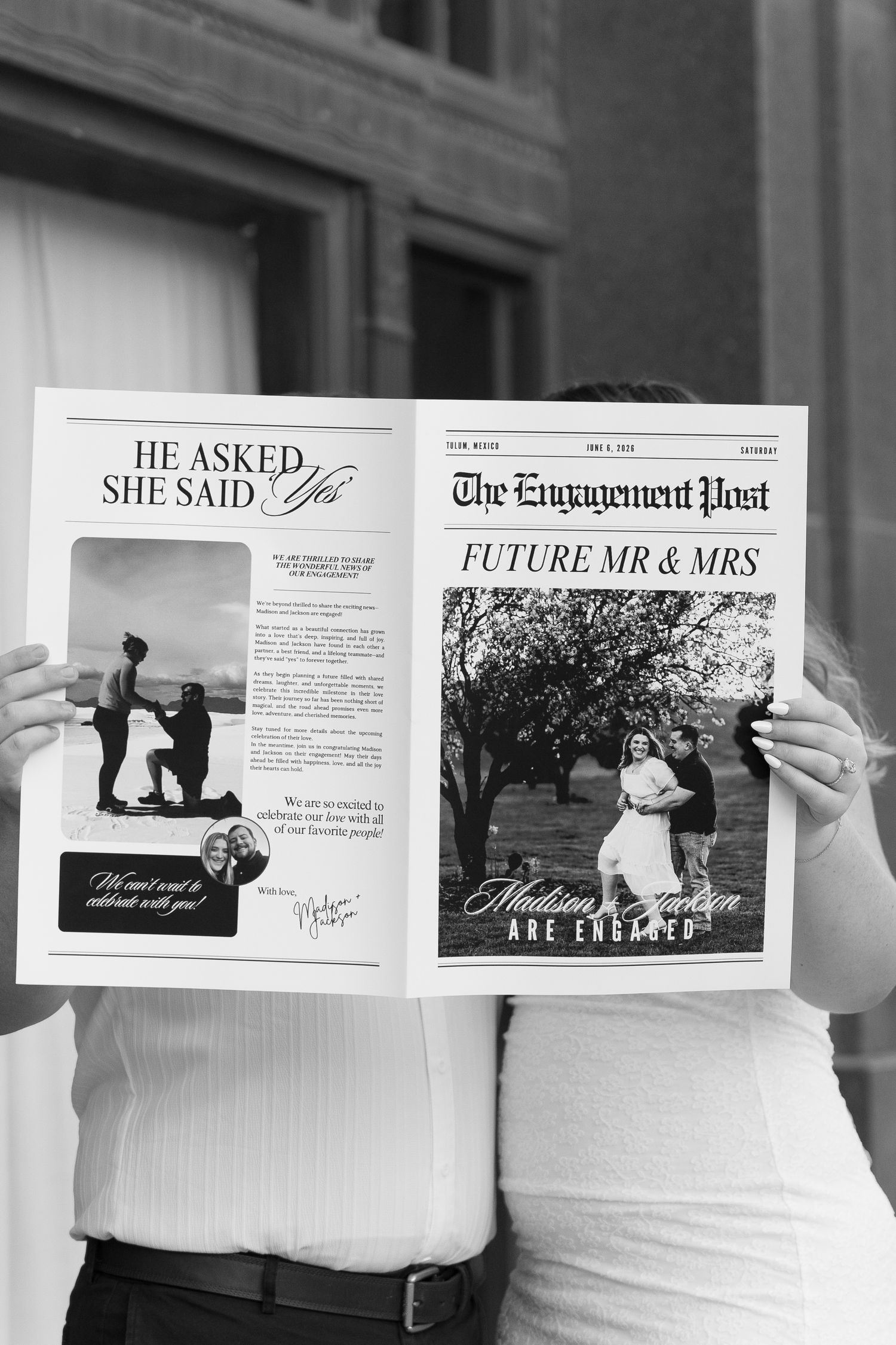 Couple holding custom engagement announcement newspaper prop during photo session.