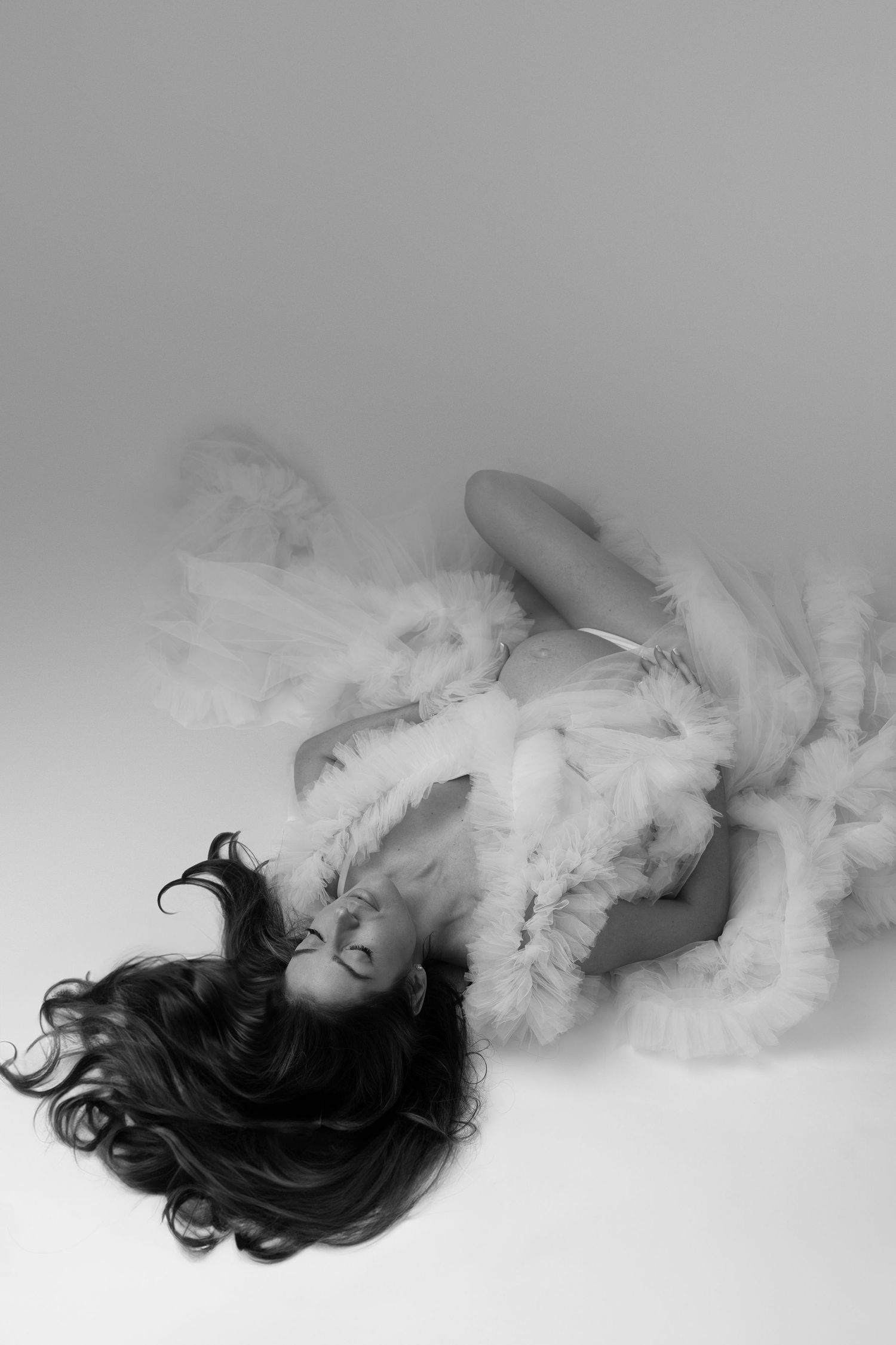 Artistic black and white portrait sequence showing dark hair dissolving into ethereal white smoke against a light background.