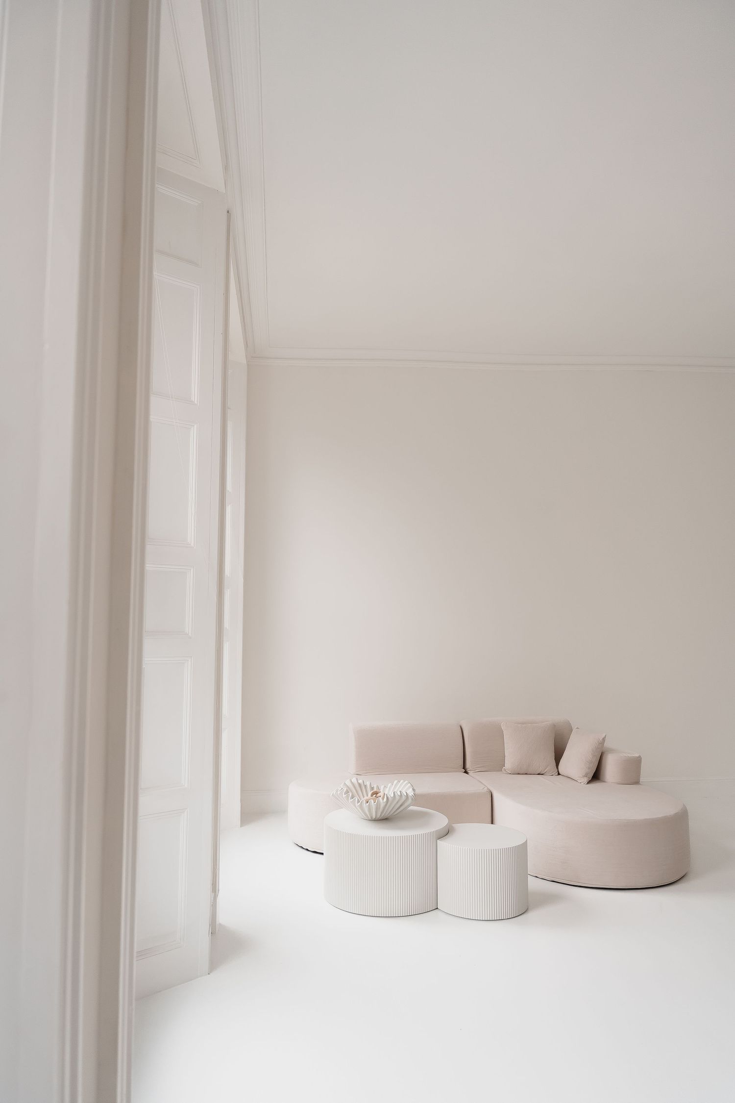Minimalist white CONTENT studio BOURNEMOUTH POOLE interior with curved beige seating arrangements.