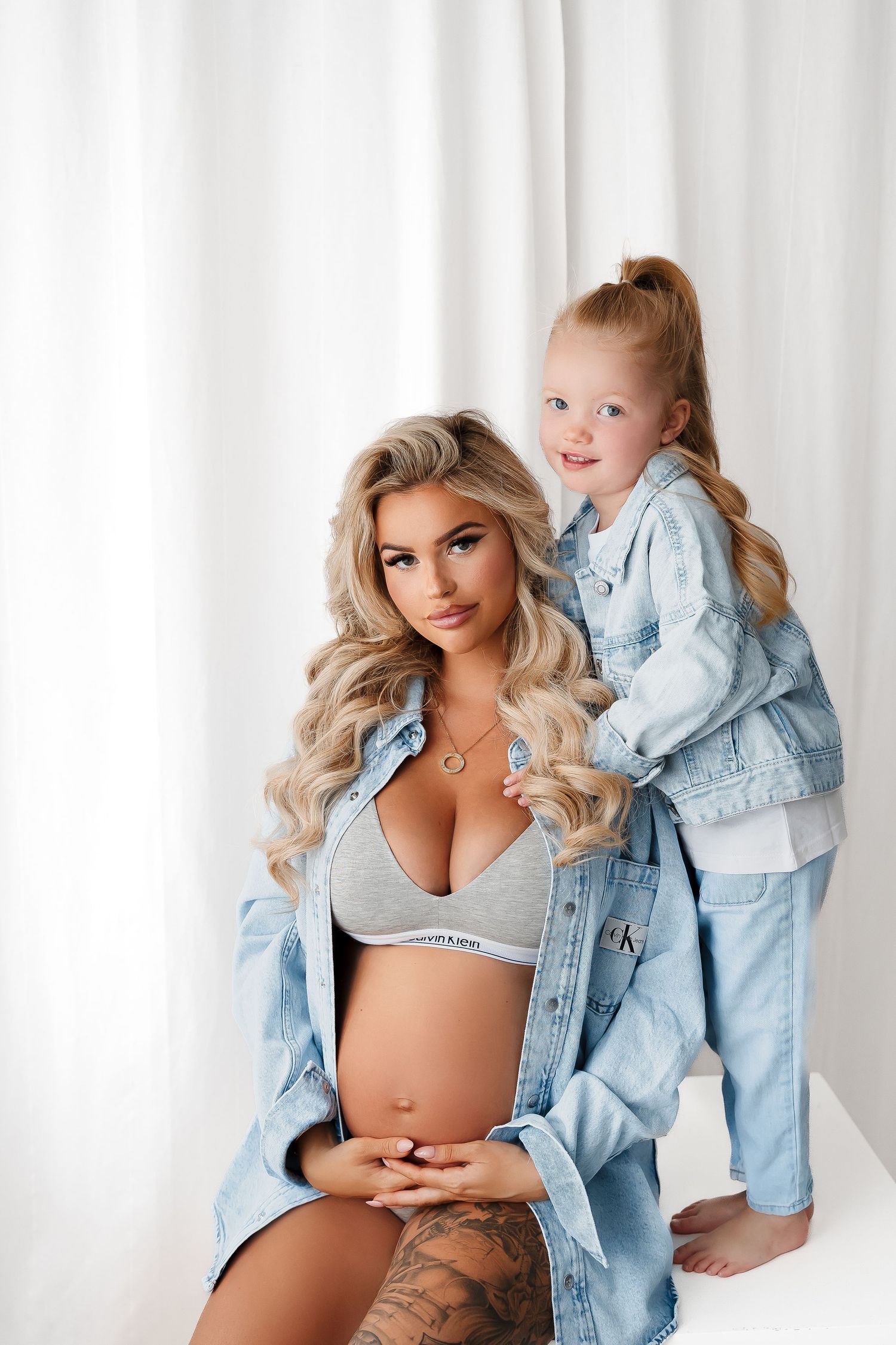 Casual maternity photoshoot featuring denim jacket and Calvin Klein style.