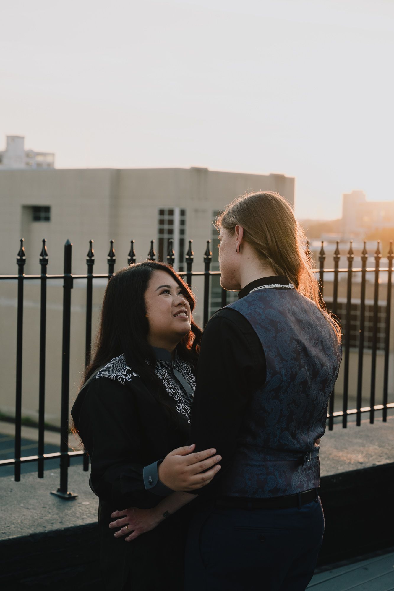 A queer lesbian couple hold each other during sunset at their wedding.