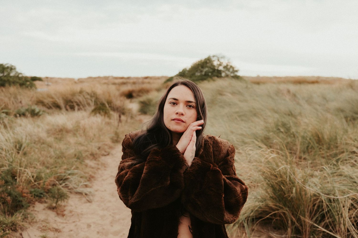 Dramatic portrait series with moody lighting in natural outdoor setting.