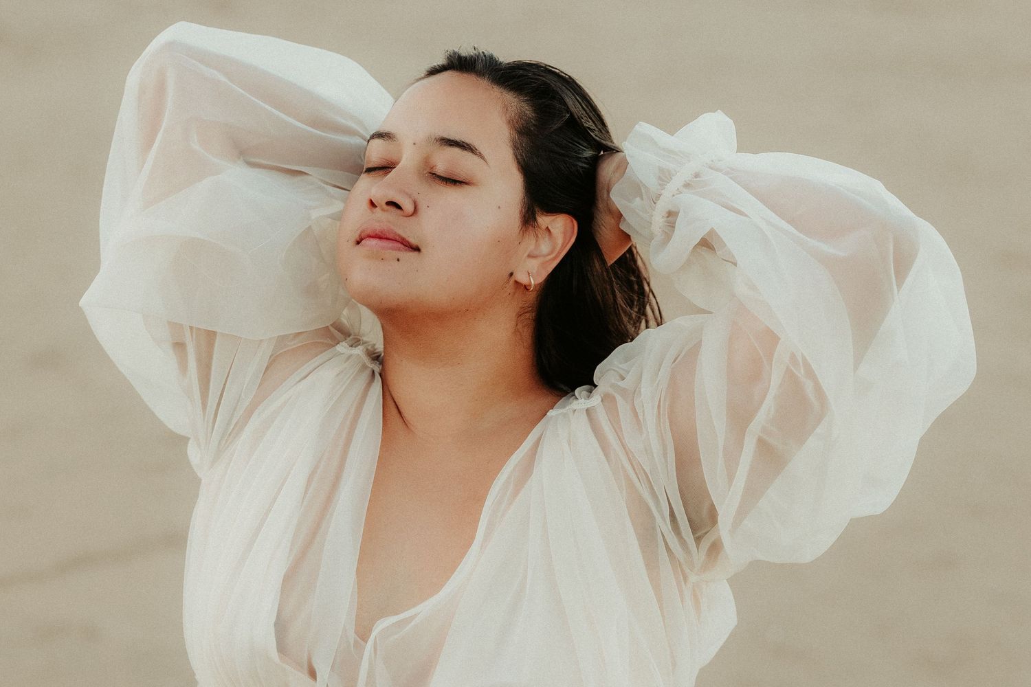 Ethereal portraits in flowing white fabric against neutral backdrop.