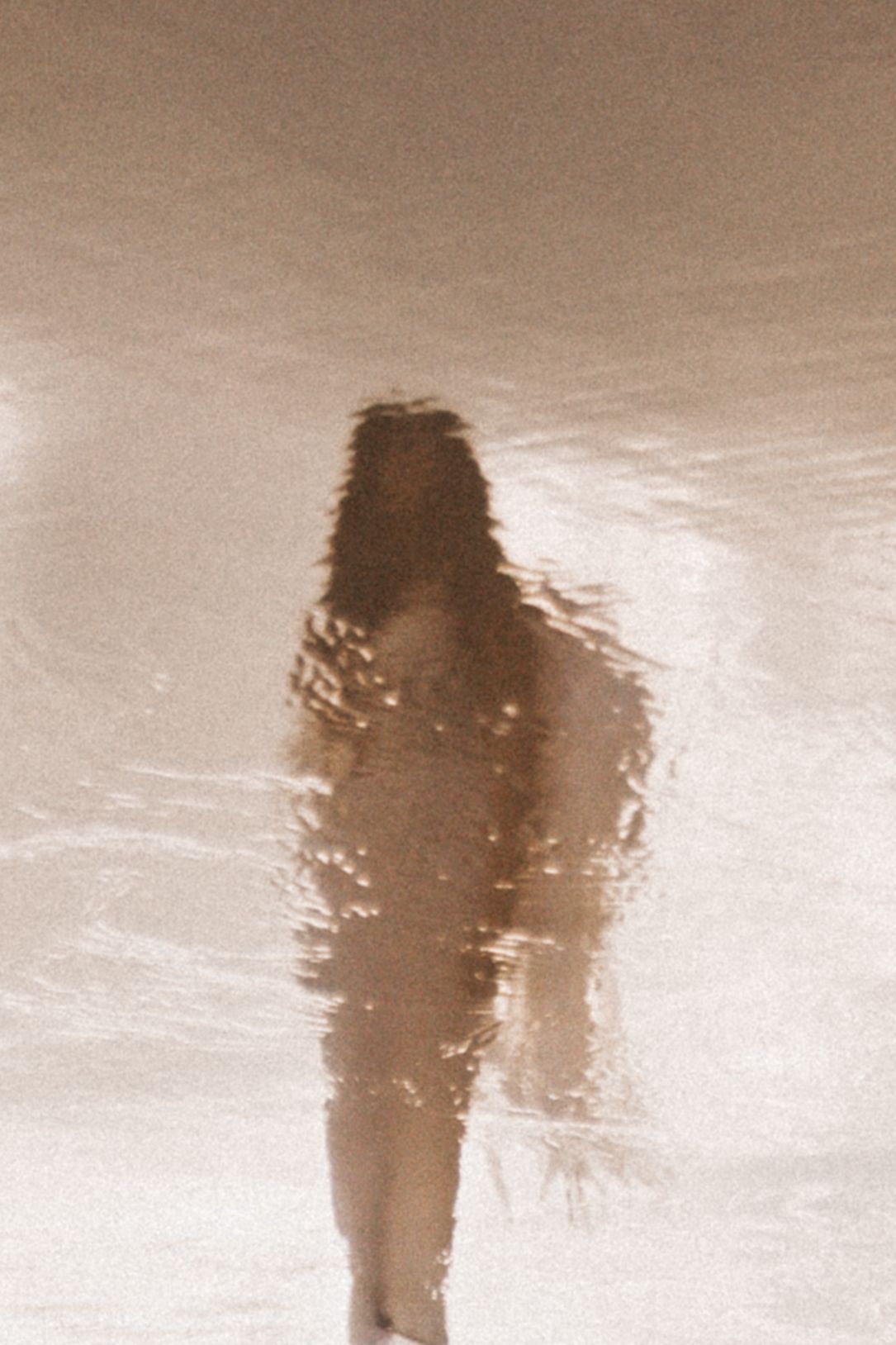A series of sepia-toned silhouettes of a figure with flowing hair walking through a misty or foggy landscape.