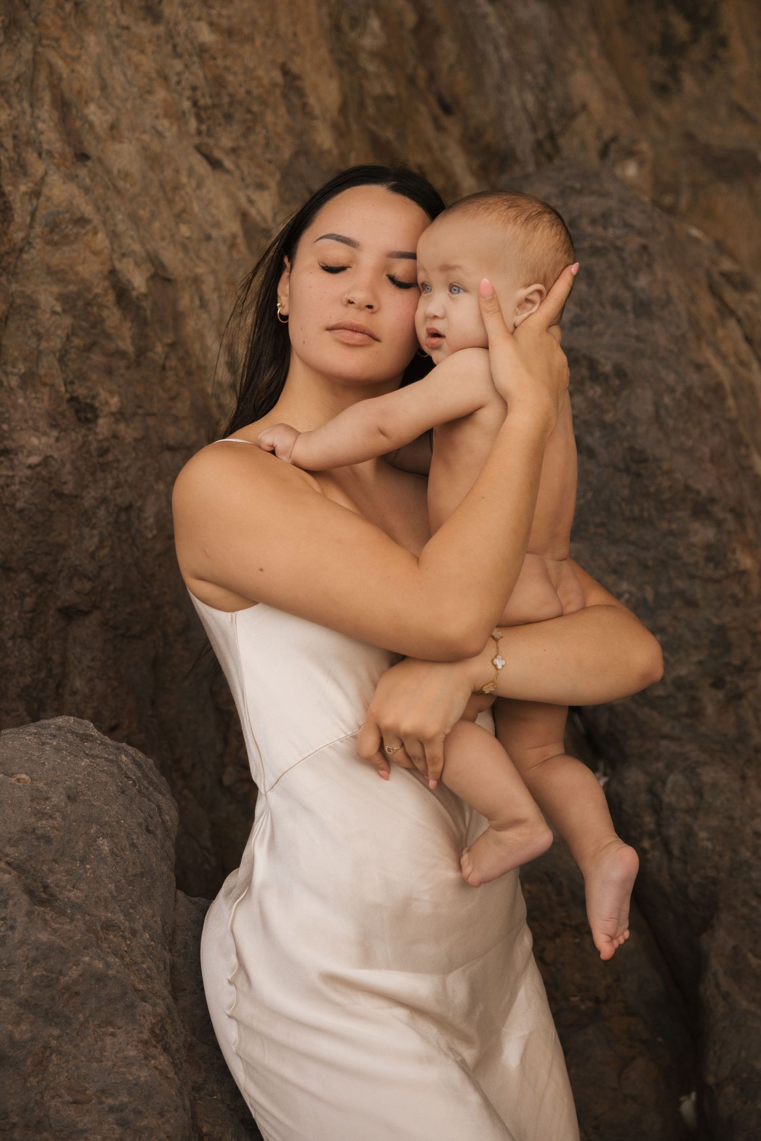 Artistic portrait featuring soft white fabric contrasting against rough stone textures.