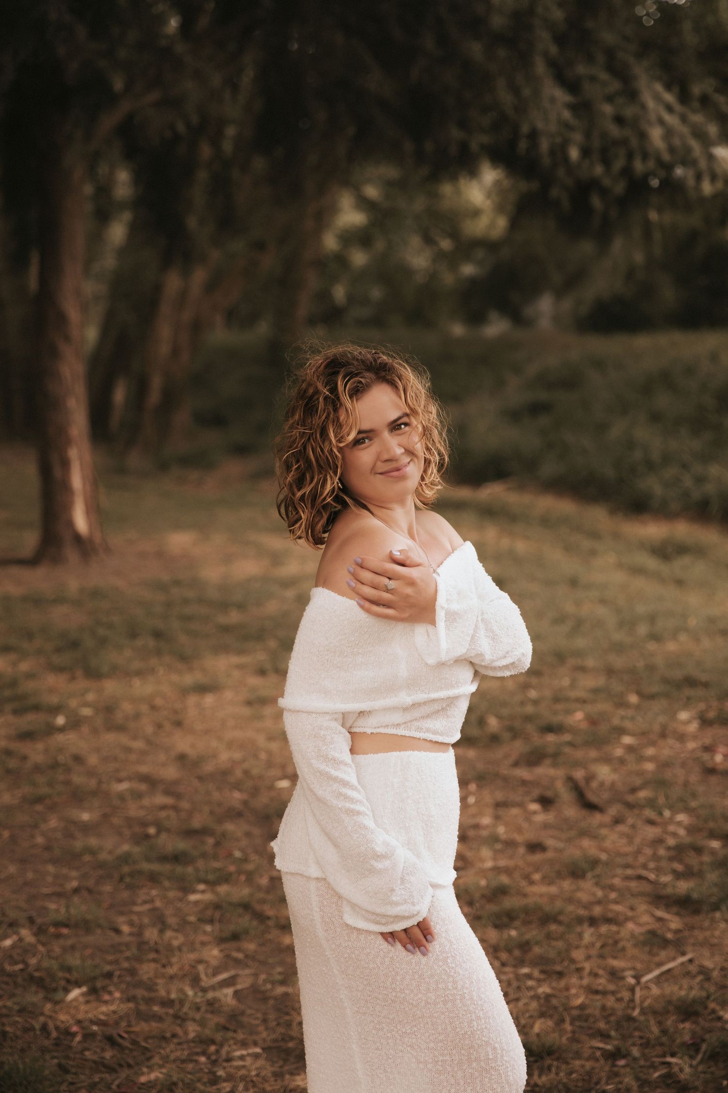 Natural light portrait series showcasing white two-piece outfit in forest setting.