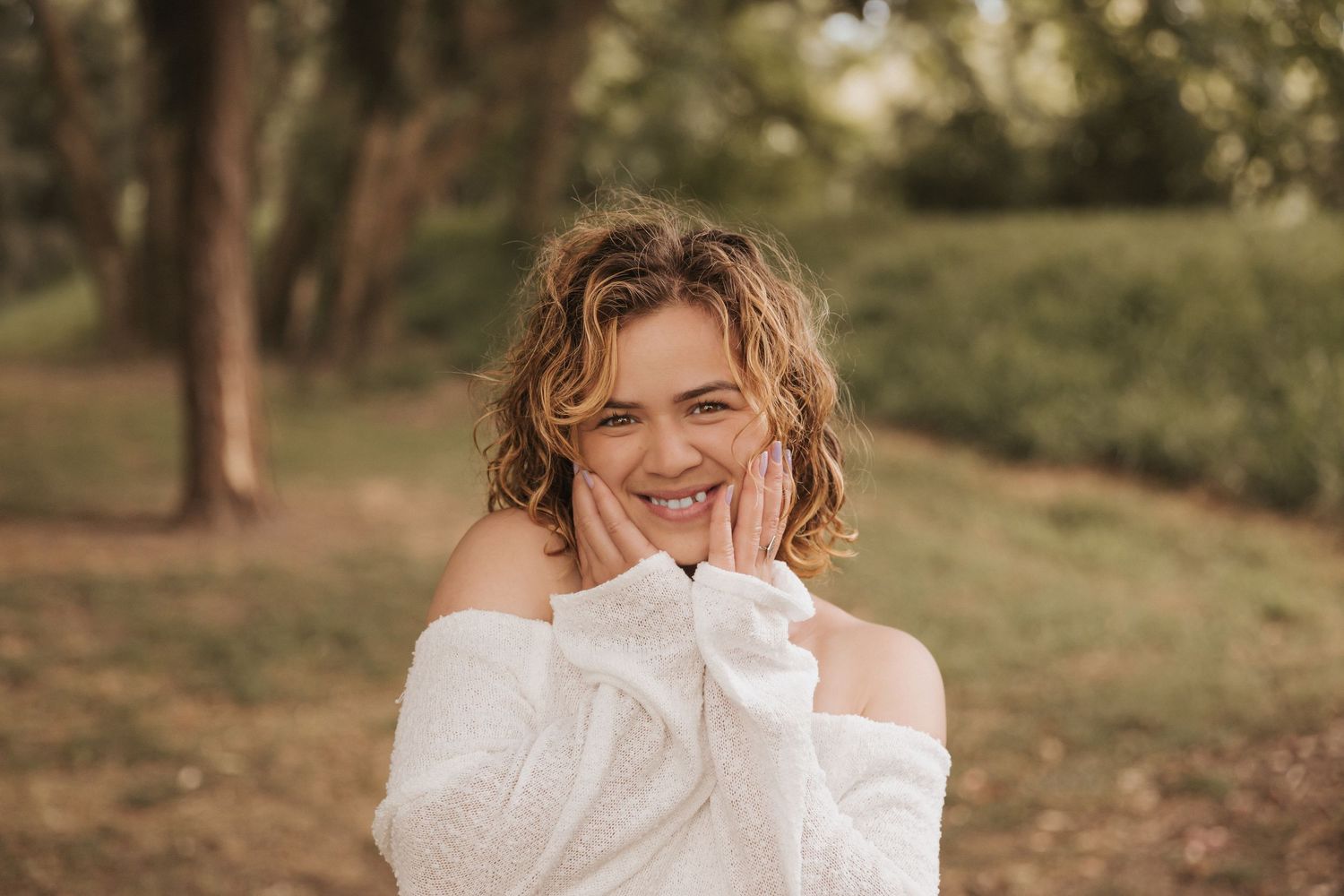 Dreamy outdoor photoshoot featuring soft expressions and white off-shoulder attire.