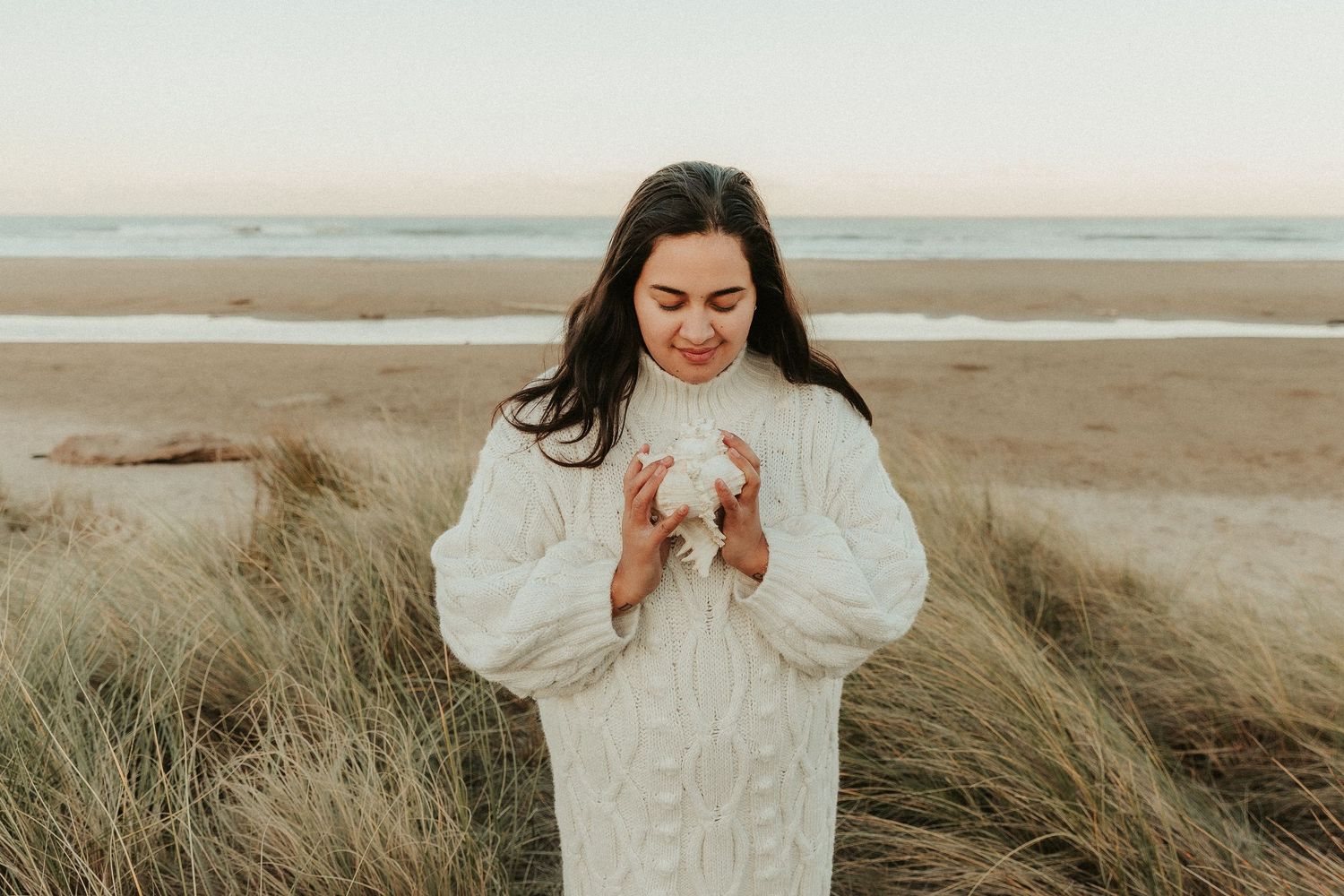 Natural lifestyle portraits on a beach with warm sunset lighting and coastal vegetation.