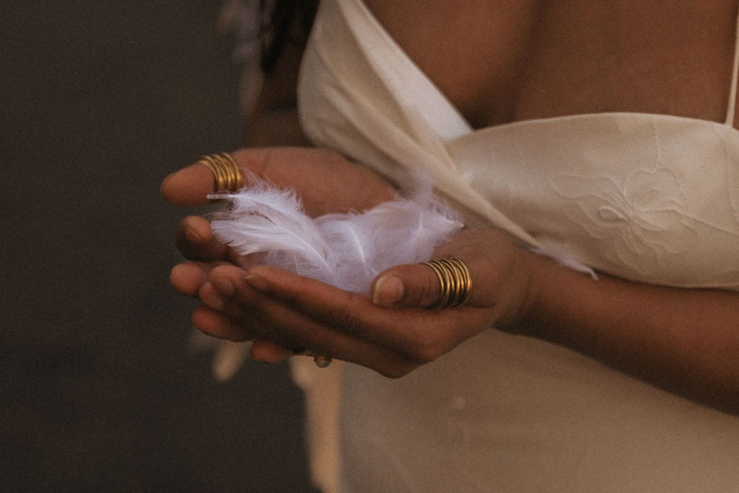 Close-up shot of hands exchanging gold wedding rings during a marriage ceremony.