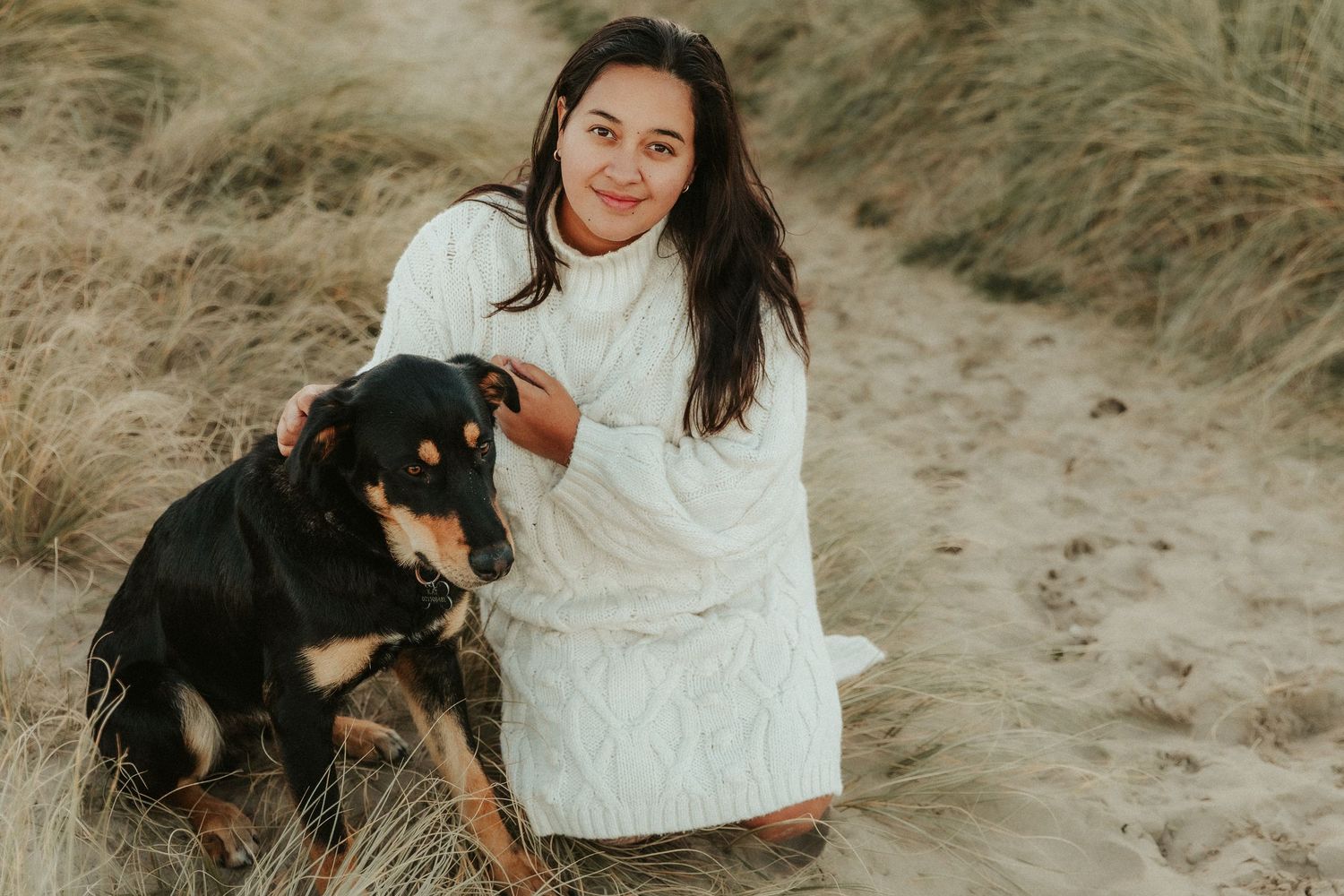A romantic outdoor photoshoot on a sandy hill with natural golden lighting.