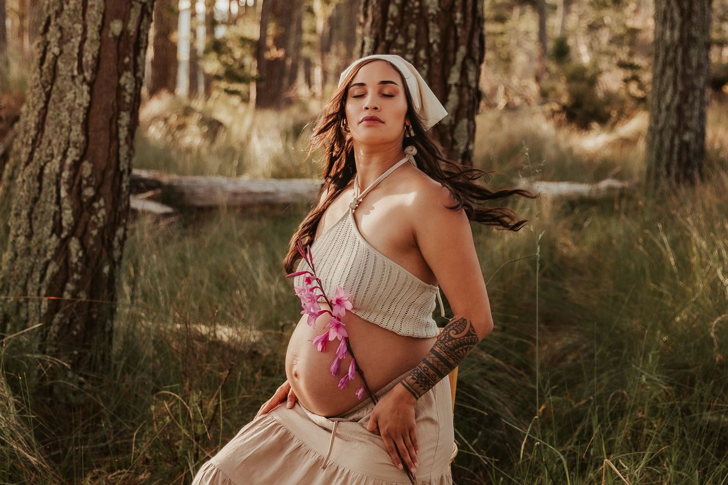 Outdoor maternity photography in forest with warm evening light.
