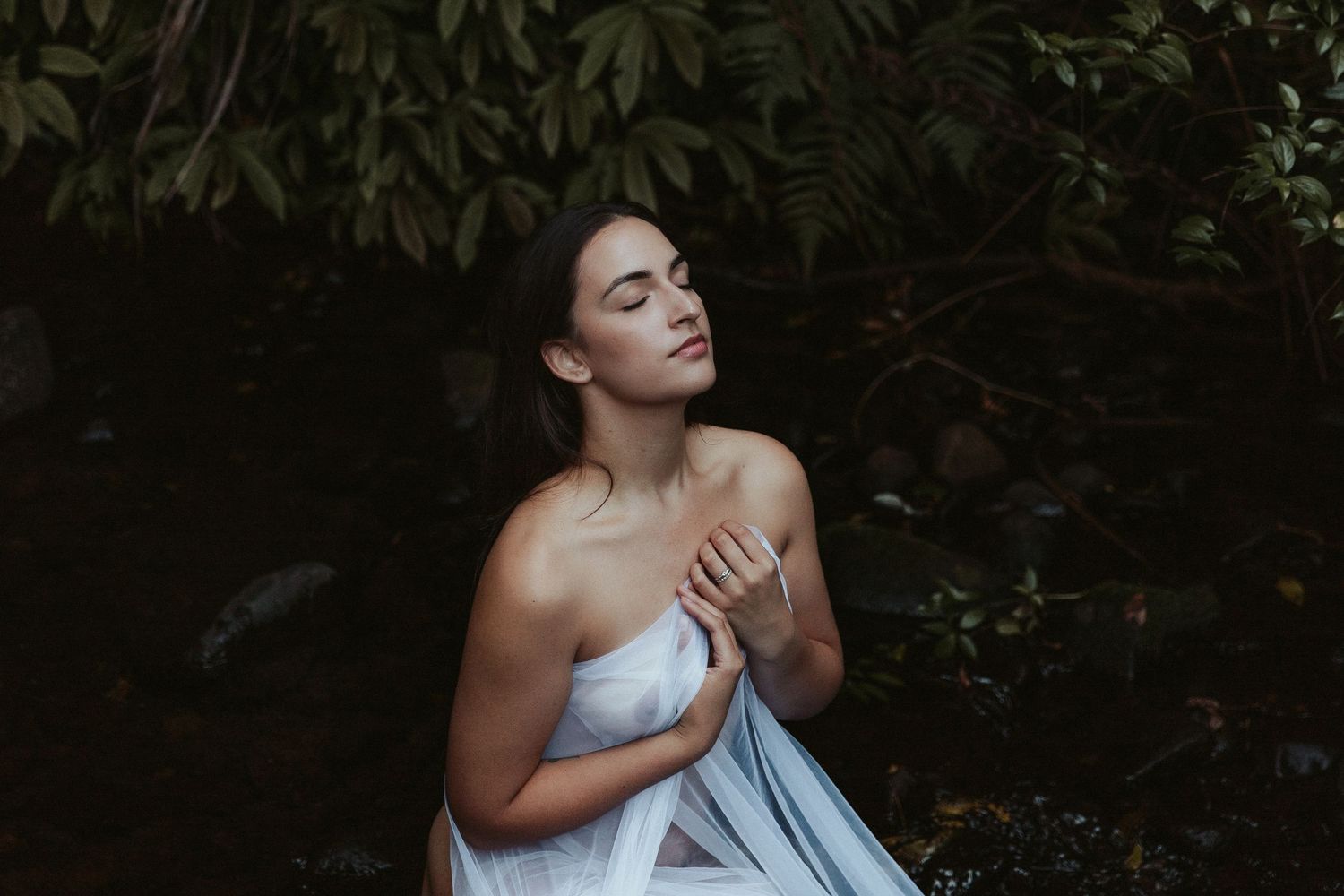 Dramatic portraits among dark foliage creating a mysterious atmosphere.