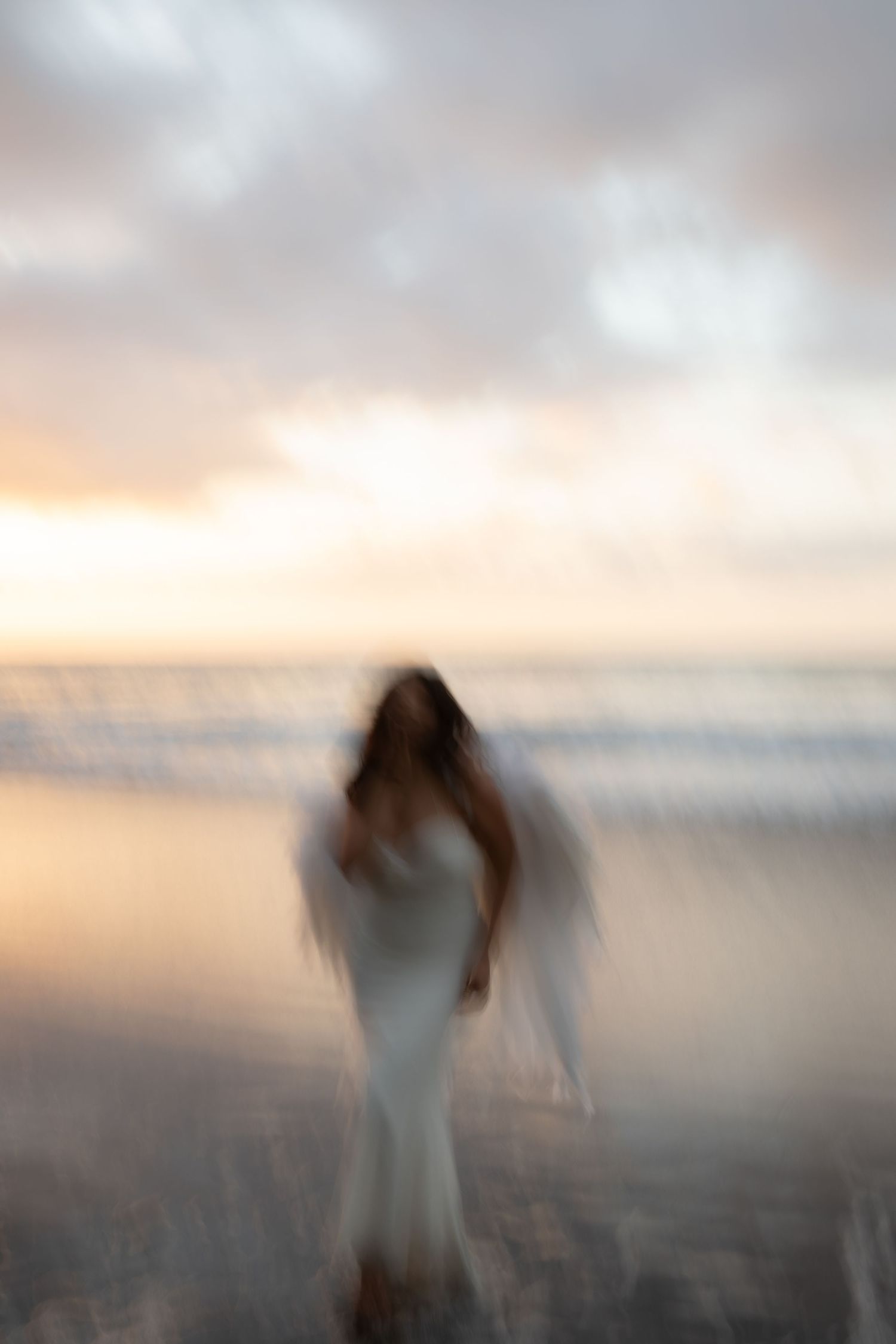 A sequence of ethereal figures in white dresses moving against a misty sunset sky creates a dreamy motion blur effect.