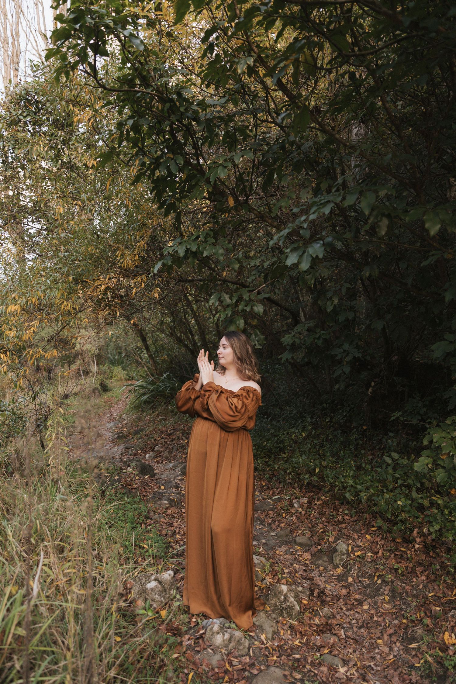 A rustic brown dress photographed in sequence against autumn forest foliage.