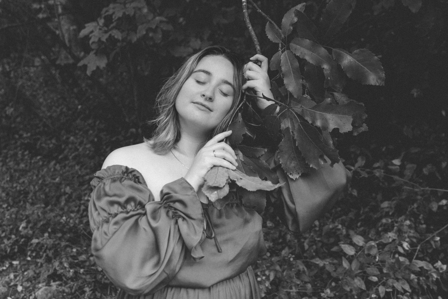 Dramatic black and white portrait showcasing a vintage-inspired dress in nature.