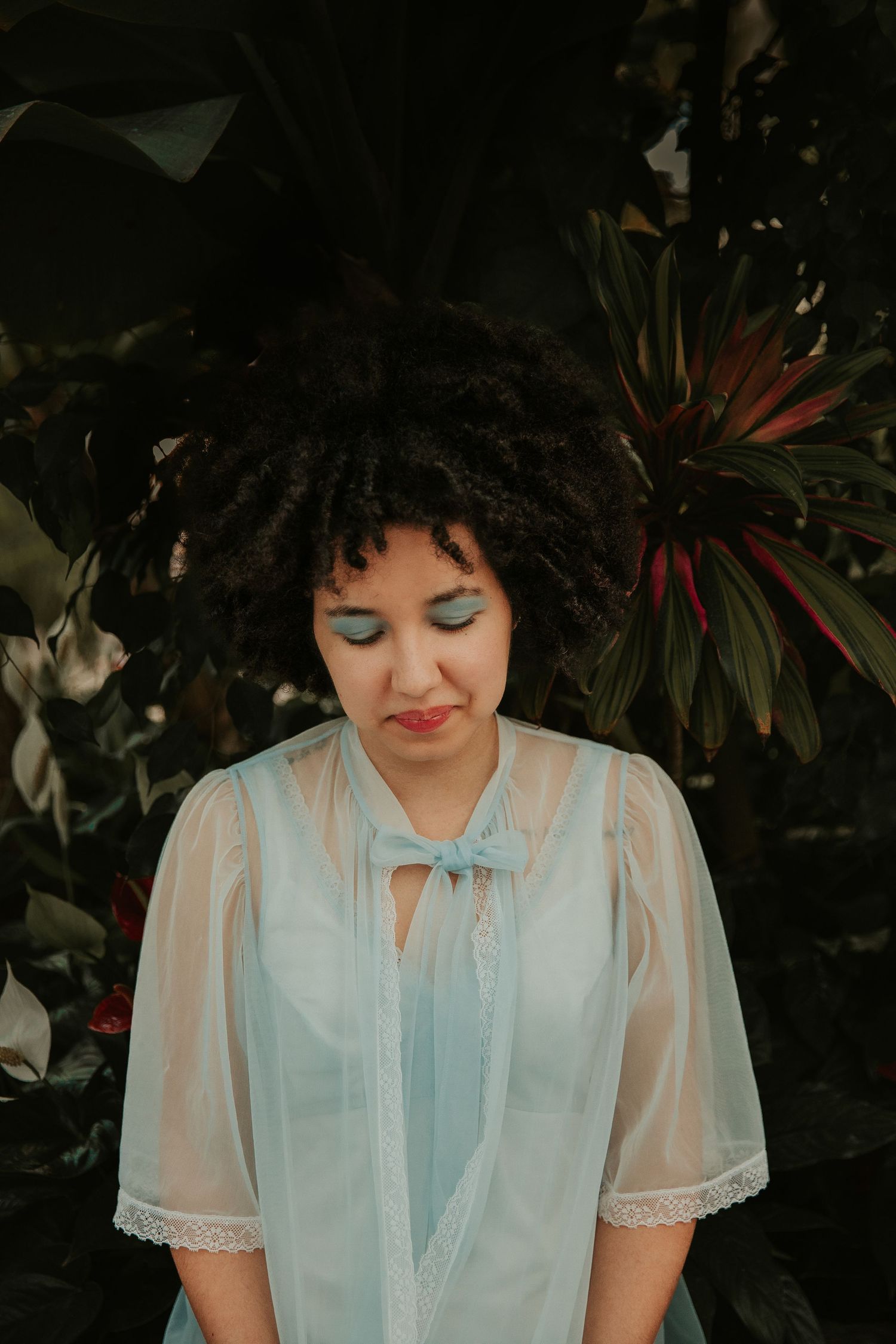 Portrait in vintage-inspired light blue dress with delicate lace details.