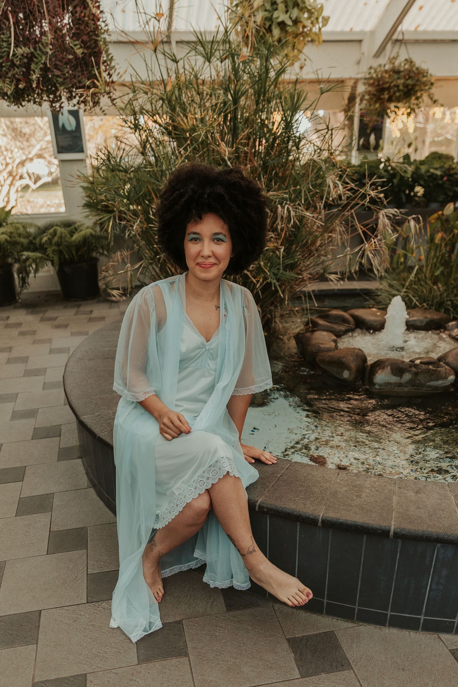 Candid moments captured in pale blue dress on garden patio.