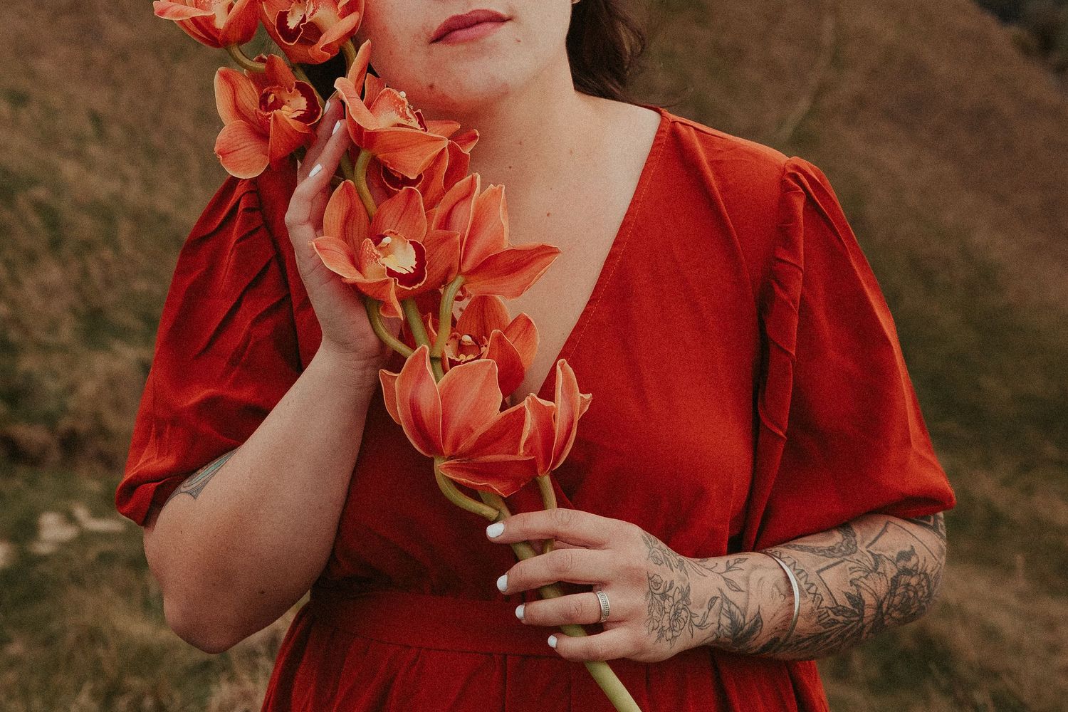 Close-up portrait with coral-colored flowers against a dark background.