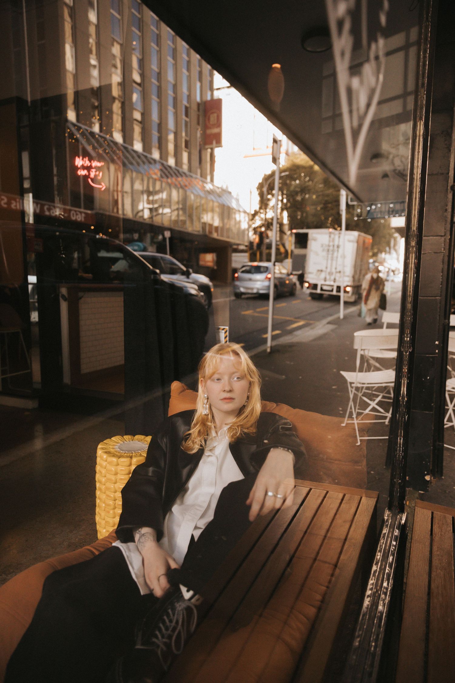 Urban street scene with wooden benches and buildings at dusk.