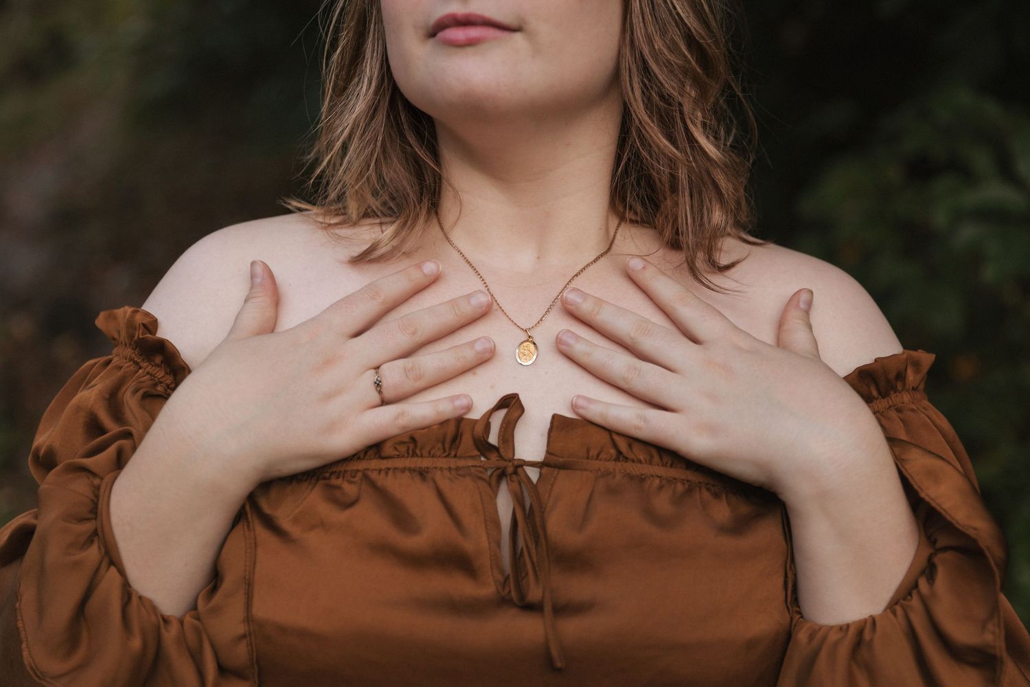 Close-up detail of a brown dress with ruffled collar and delicate neckline design.