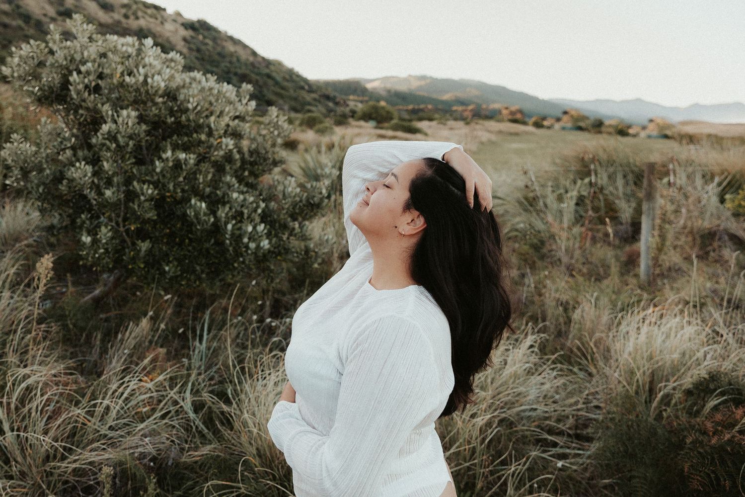 Ethereal outdoor portrait session in a golden hillside setting at sunset.