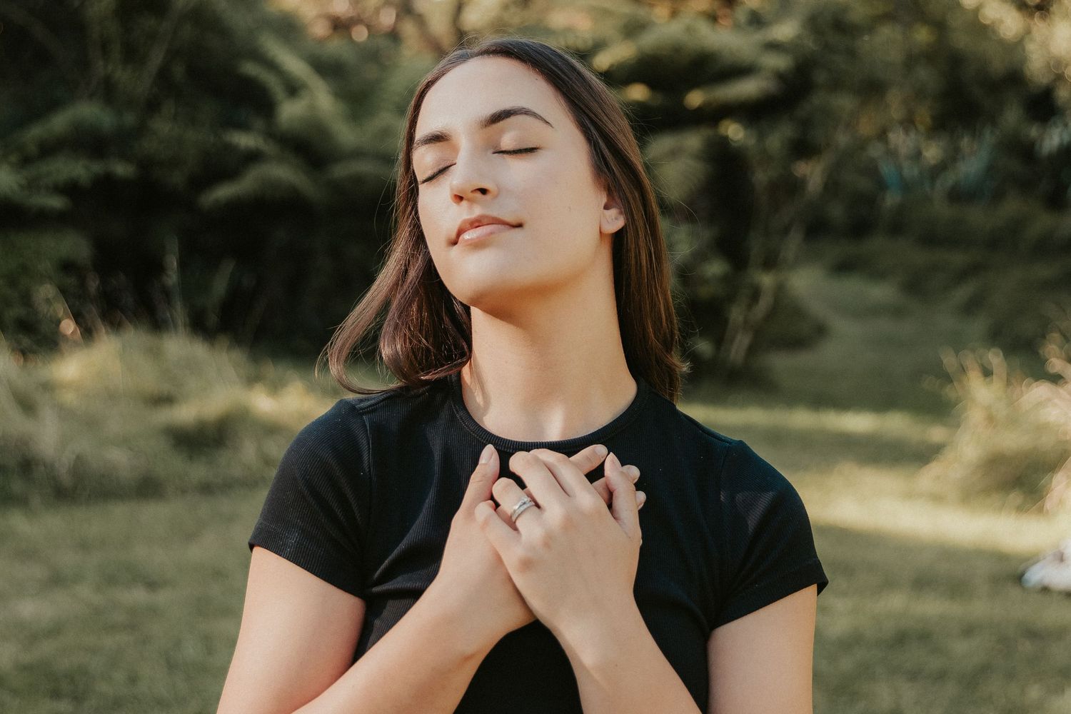 Artistic outdoor portraits showing expressive poses in black attire against a natural landscape.